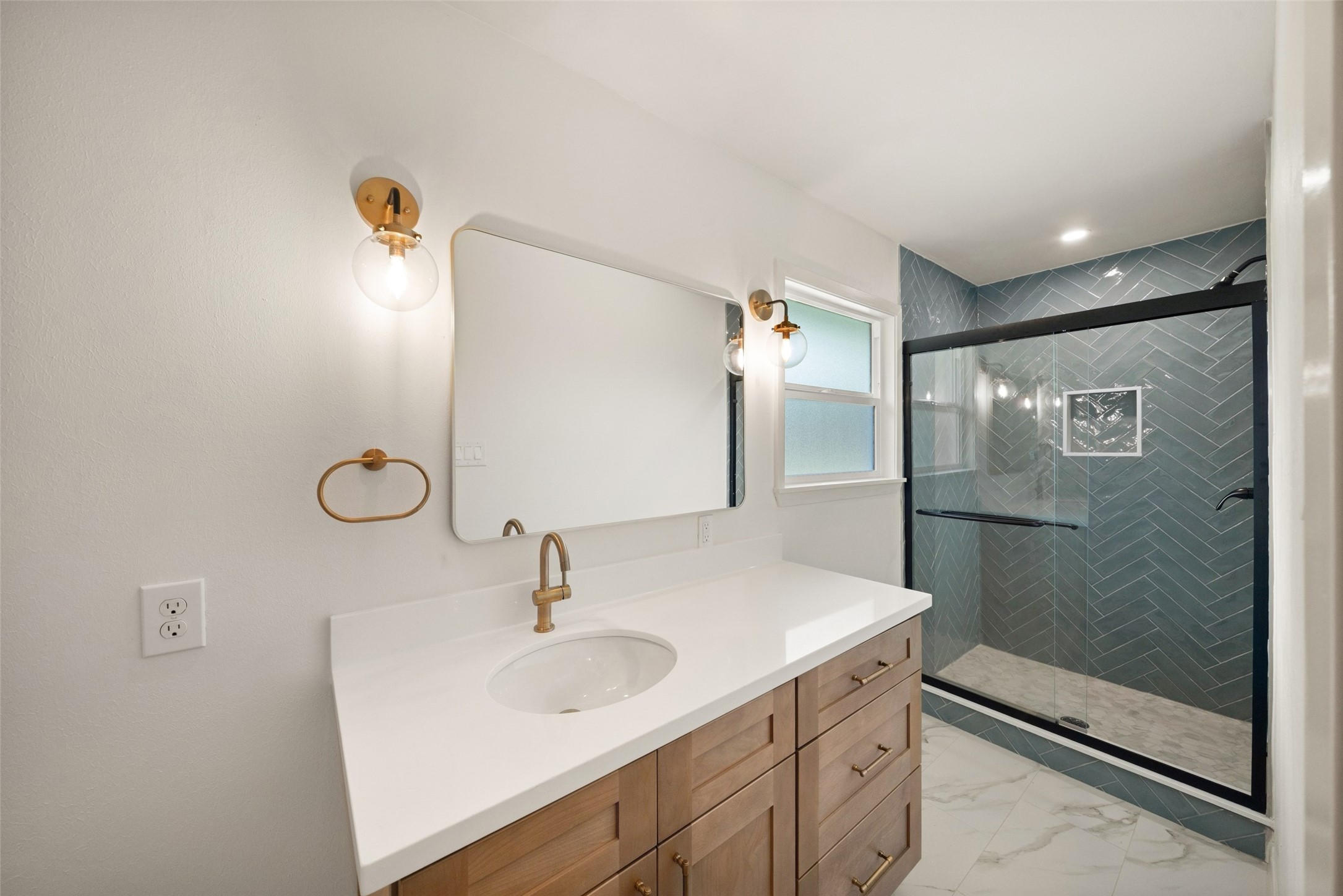 Elegant bathroom featuring a modern vanity with sleek fixtures, ambient lighting, and a spacious glass-enclosed shower with stylish tile work.