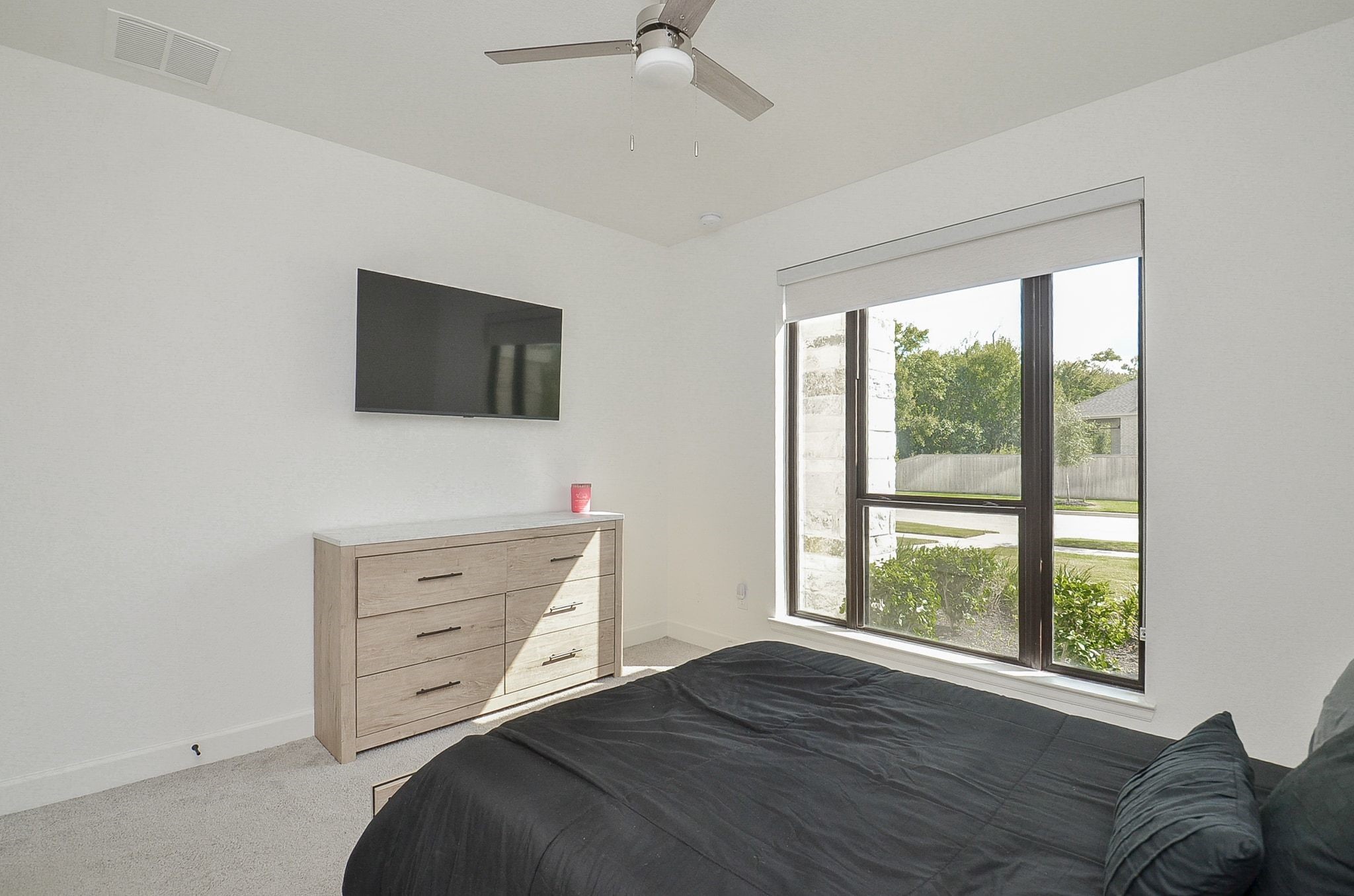 Additional view of the secondary bedroom, featuring ample space and a large window.