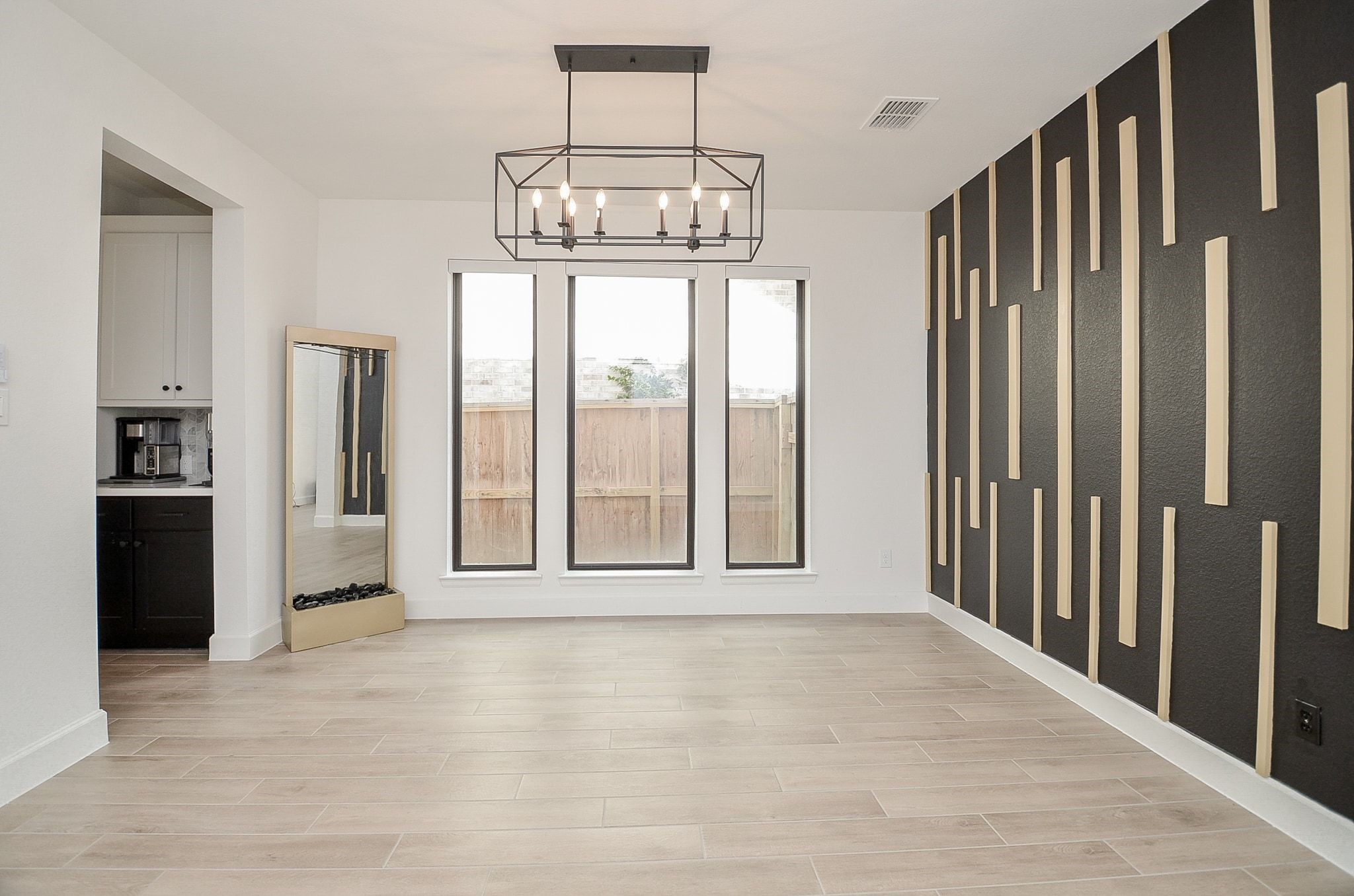 Elegant formal dining room with a stunning statement wall and contemporary chandelier.