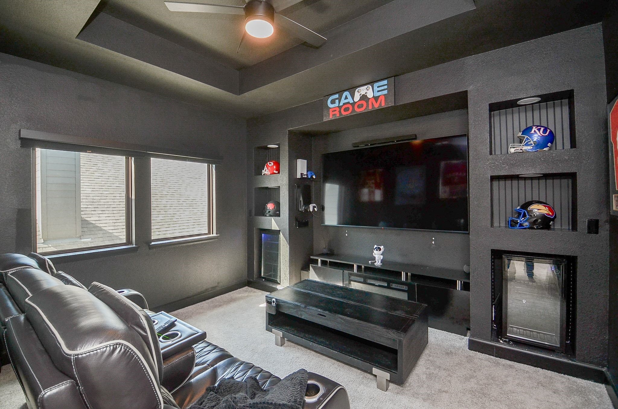 Custom-designed game room featuring built-in entertainment center, display niches, and beverage refrigerators. TV is included.