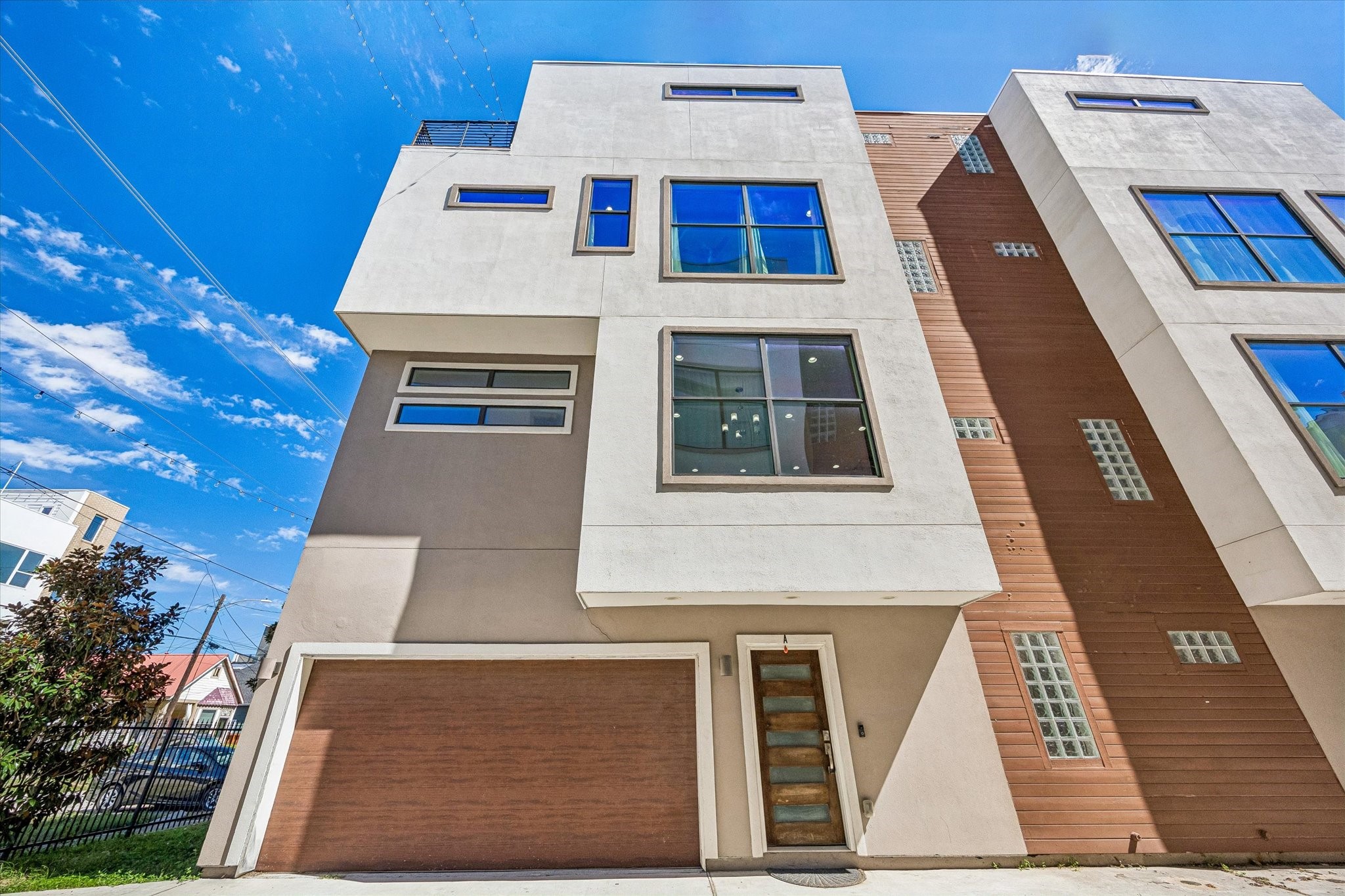 Contemporary exterior featuring clean architectural lines, oversized windows, an attached garage, and a glass-paneled entry door. Contemporary exterior featuring clean architectural lines, oversized windows, an attached garage, and a glass-paneled entry door.