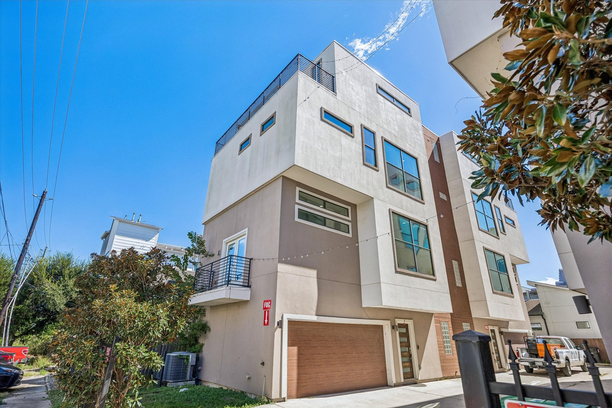 Angled exterior view highlighting the homes multiple levels, distinctive window placement, side balcony, and rooftop terrace. Angled exterior view highlighting the homes multiple levels, distinctive window placement, side balcony, and rooftop terrace.
