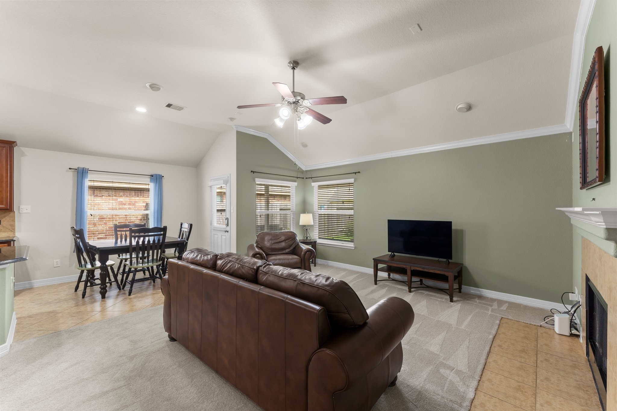 Spacious living area with high ceilings and abundant natural light, features an open layout to the kitchen and dining area.