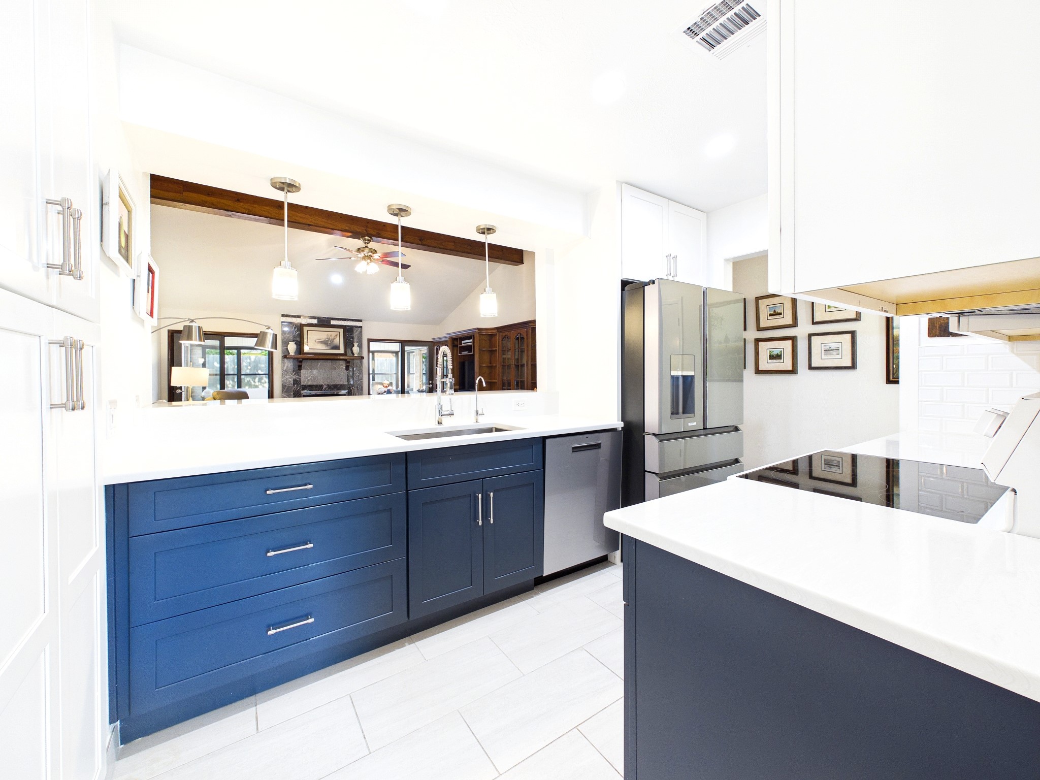 Experience modern elegance in this beautifully updated kitchen, featuring stunning blue cabinetry, sleek stainless steel appliances, and ample natural light.