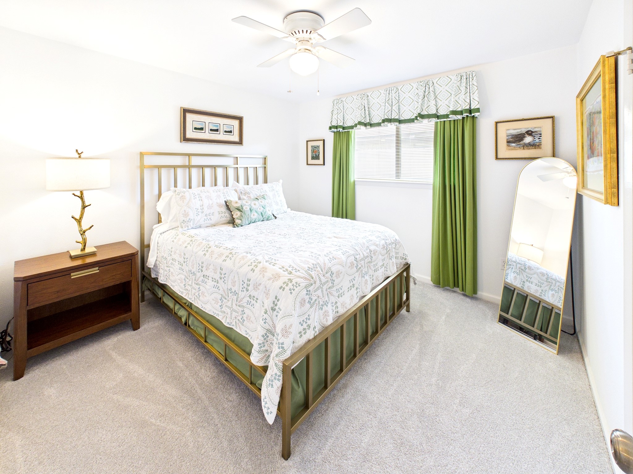 Discover a bright and inviting second guest room featuring plush carpeting, a stylish bed, and vibrant green accents, perfect for making your guests feel at home.