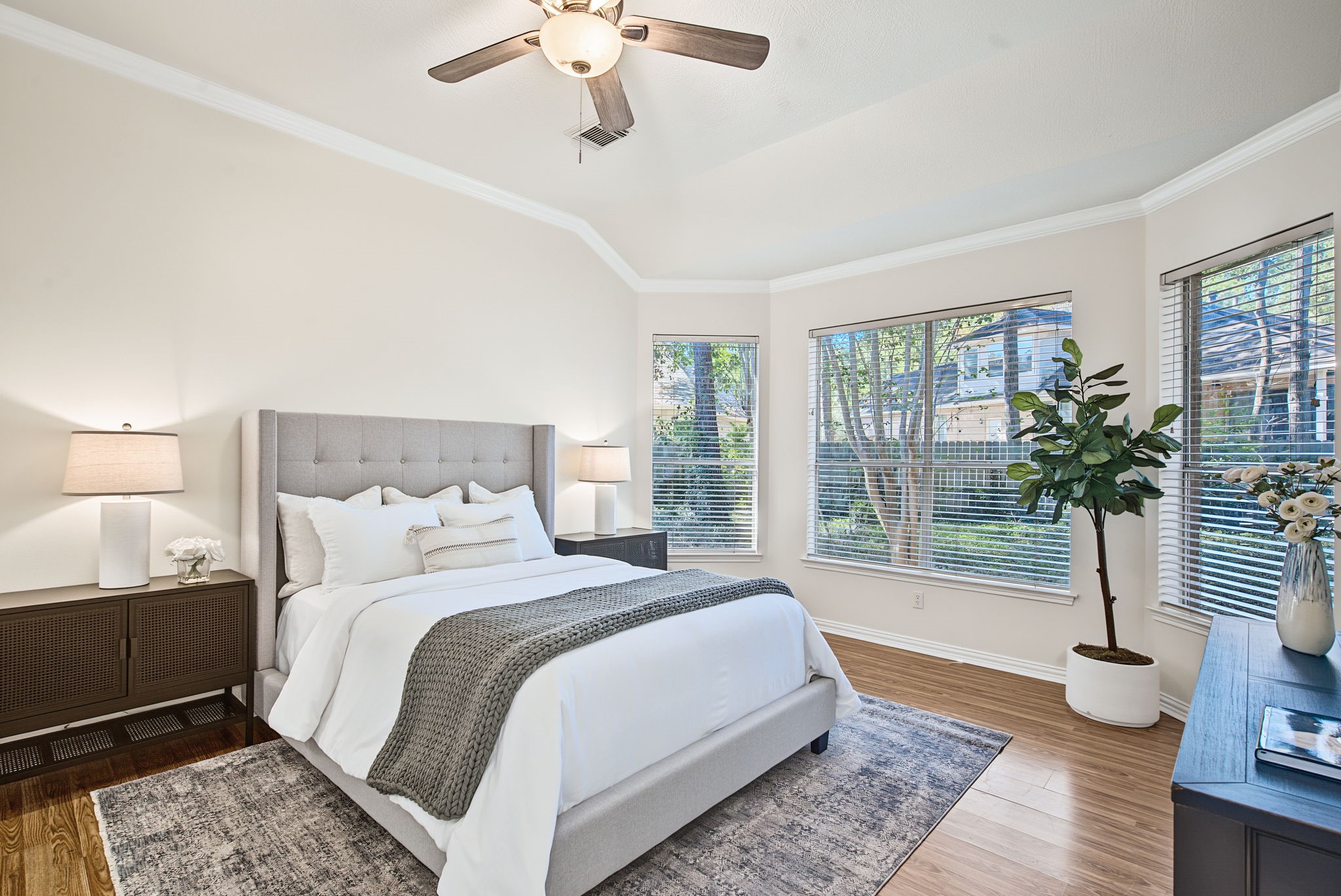 Wraparound windows bring leafy views into the primary suite, adding natural light and a connection to the homes established surroundings.