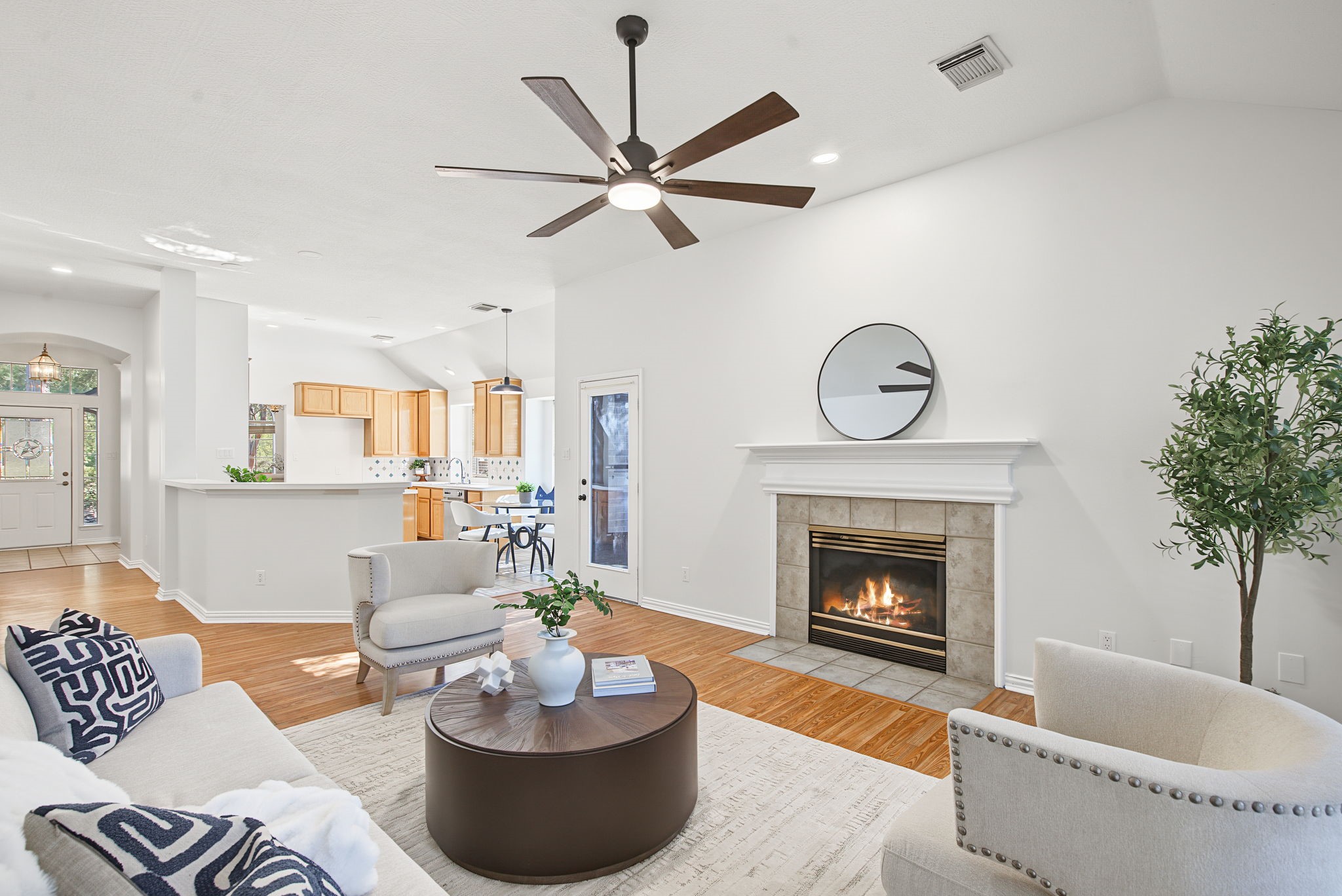 The fireplace anchors the living room, while the kitchen pass-through keeps conversation flowing between the main gathering spaces.