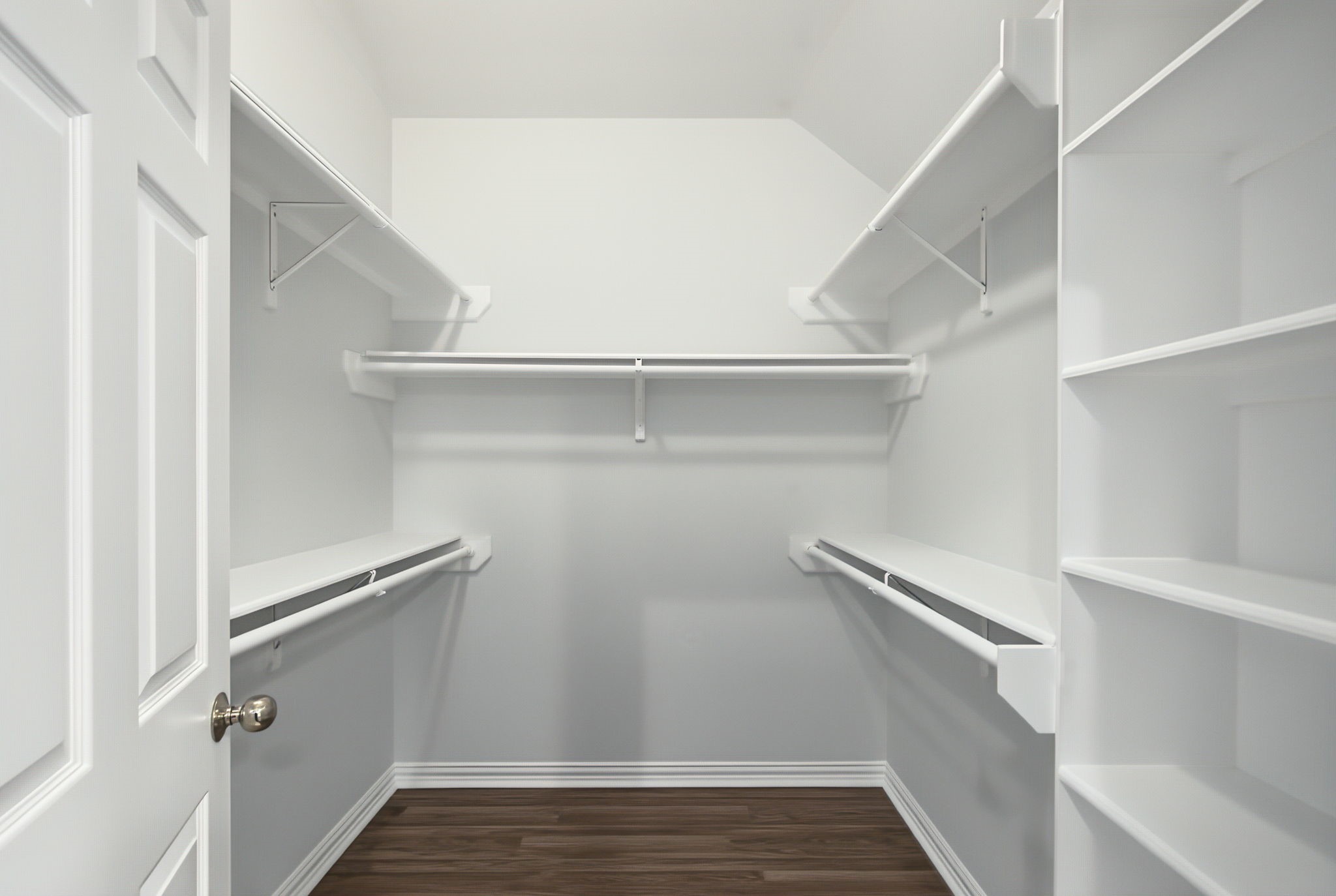 The walk-in closet features hanging space on both sides and built-in shelving for shoes, accessories, and everyday organization.