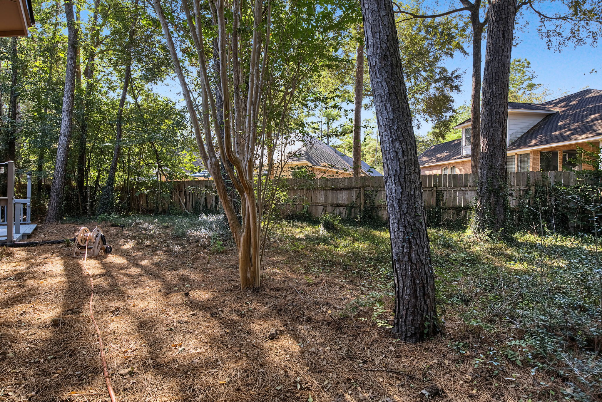 Mature trees and a fenced backyard provide an established outdoor setting with opportunities to create your own garden or gathering space.