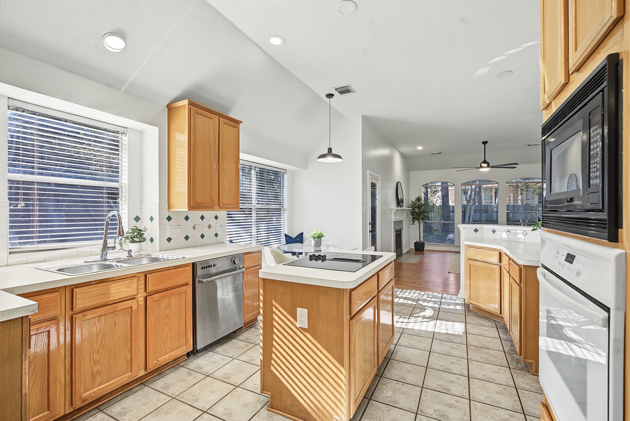 The island kitchen offers generous cabinetry, extensive counter space, and a connection to the breakfast area and living room.
