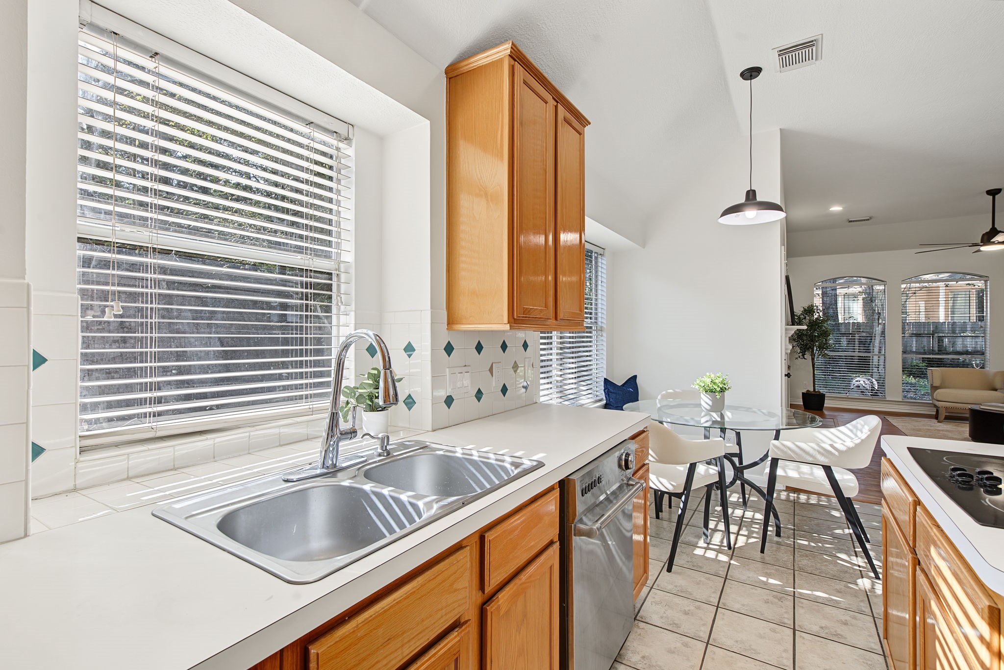 A window above the double-basin sink brings natural light to the workspace, with nearby cabinetry keeping everyday essentials within reach.
