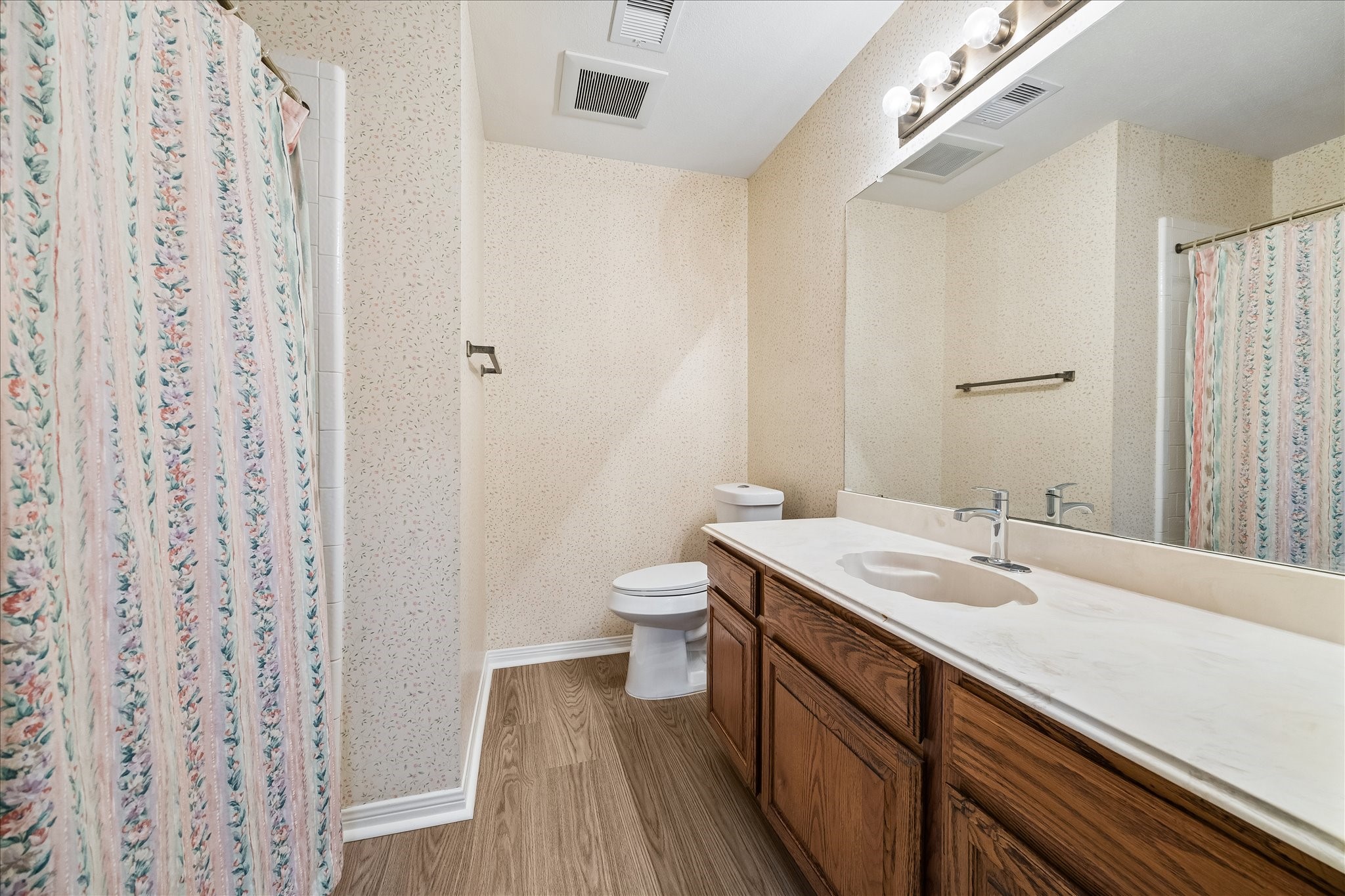 Full bathroom off the hallway with new flooring and refinished cabinets