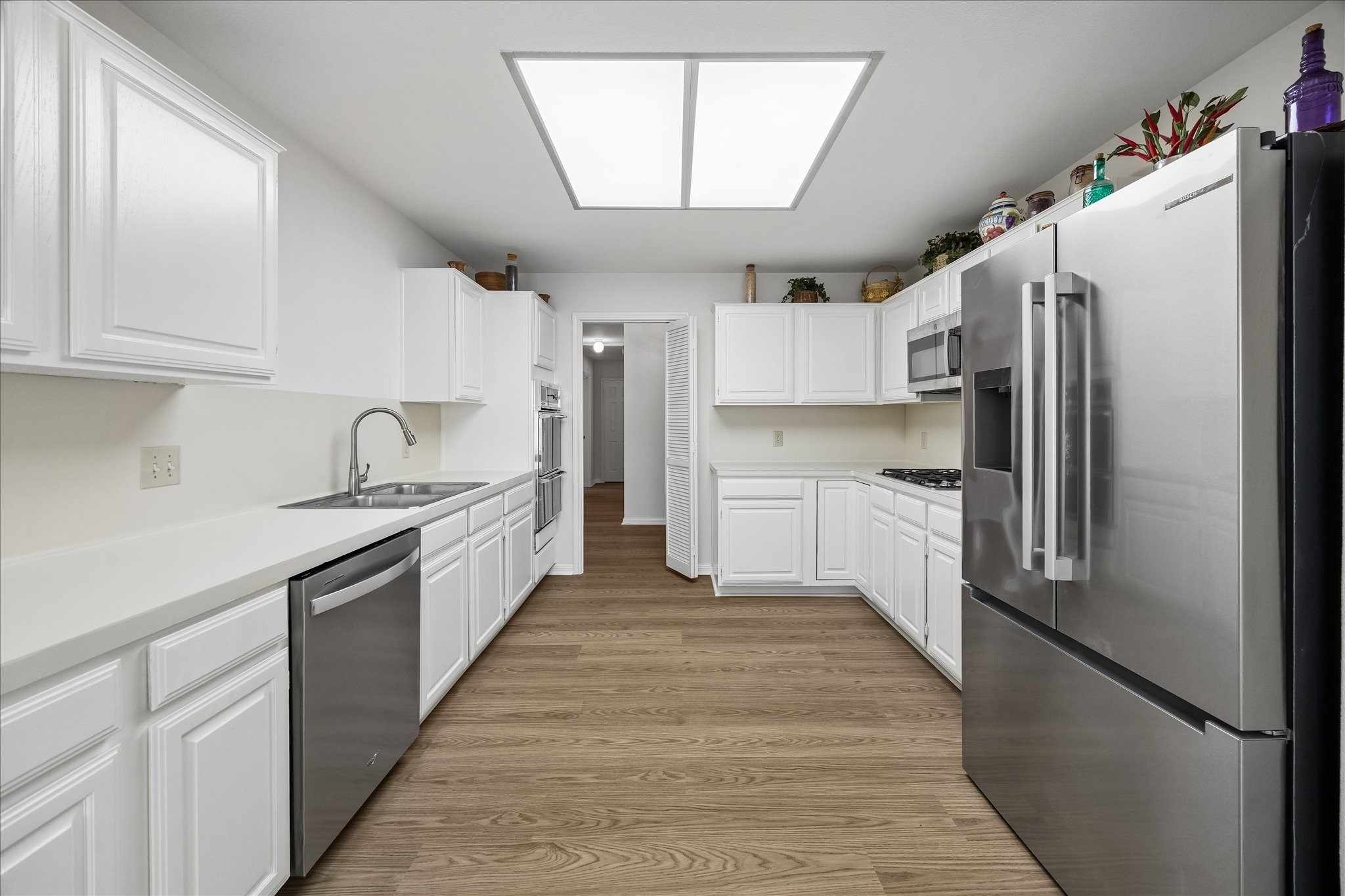 Kitchen with new flooring, fresh paint, refinished cabinets and a recently added Bosch refrigerator