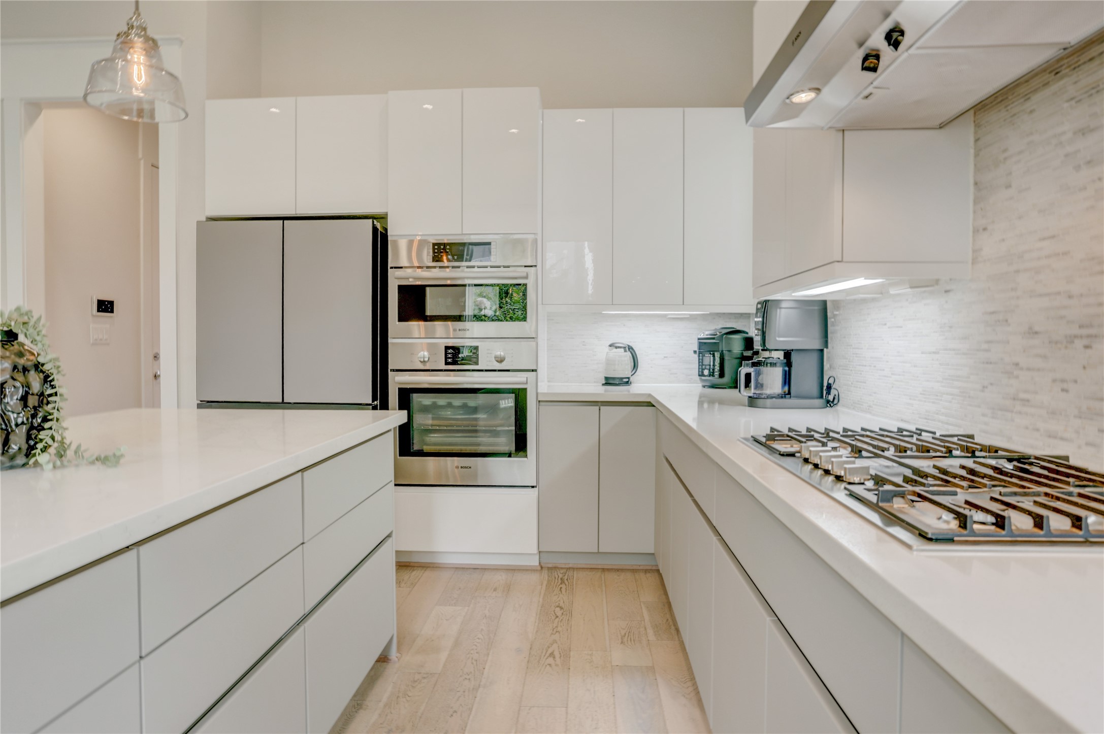 Sleek modern kitchen with high-gloss cabinetry, stainless steel appliances, and a spacious island.