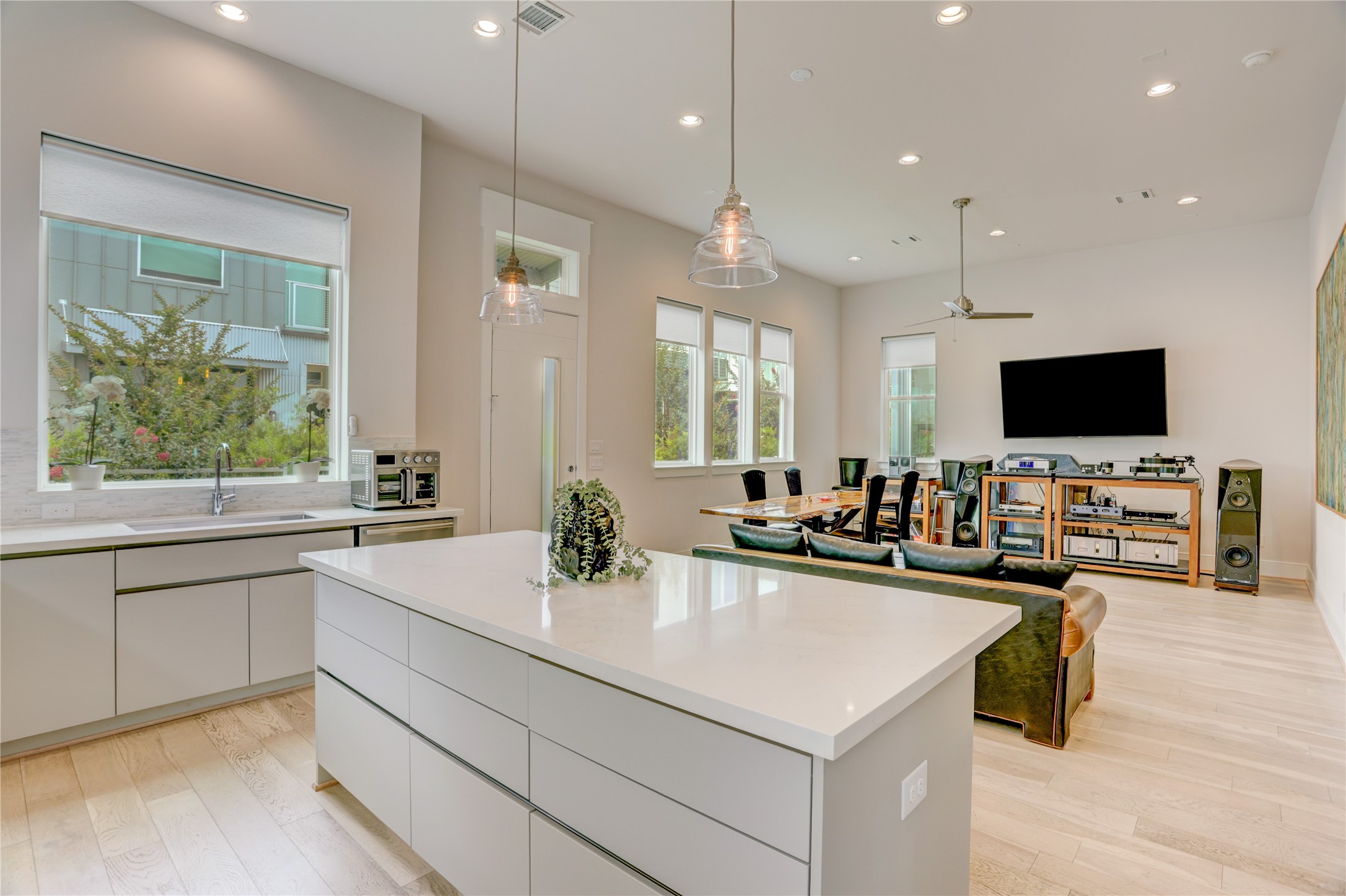 Spacious open-concept living area with modern kitchen, large island, and abundant natural light, perfect for entertaining.