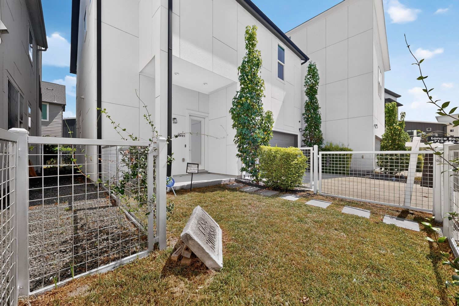 Contemporary home with sleek design, featuring a private fenced yard and modern landscaping.