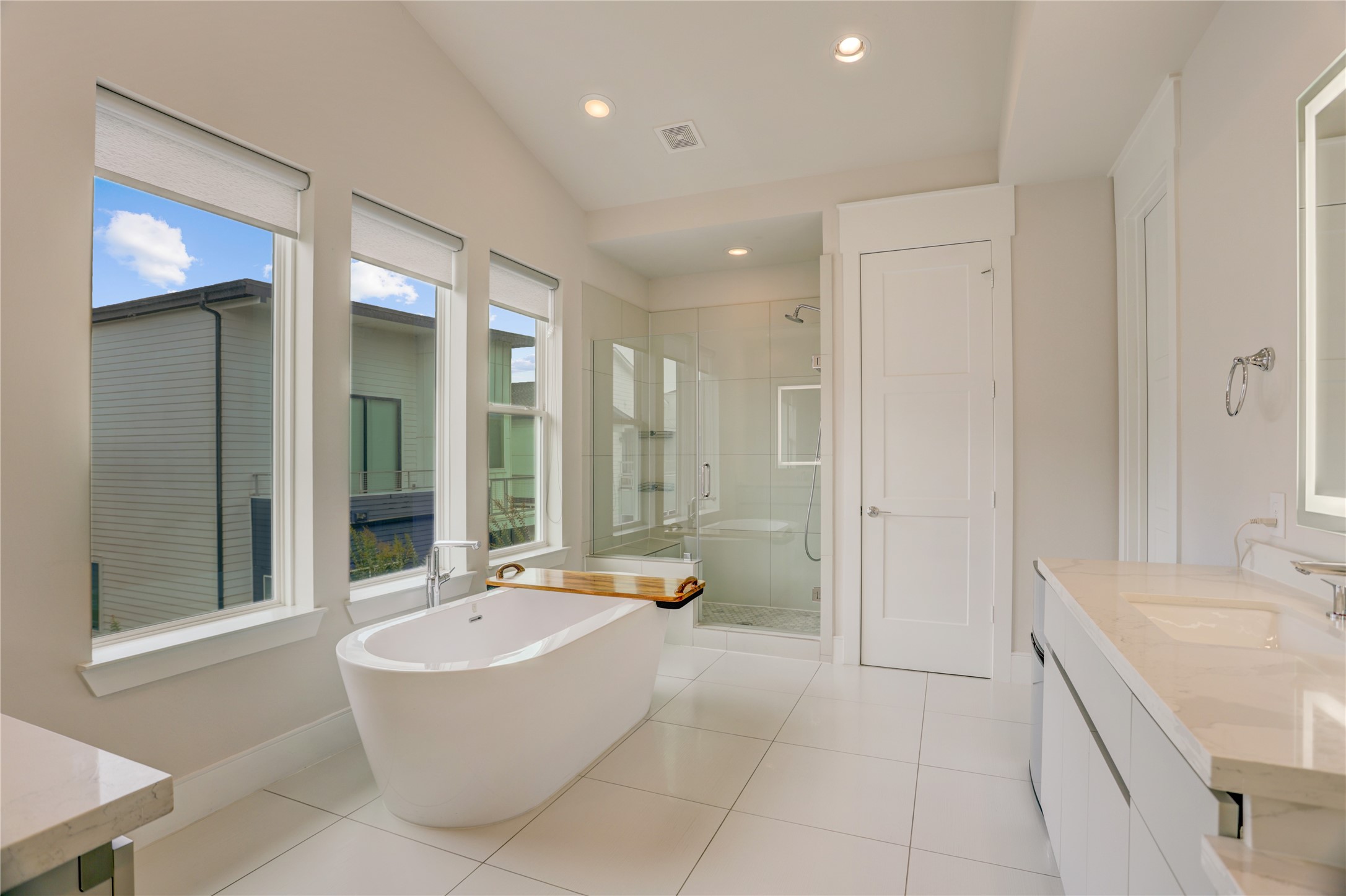 Luxurious Primary bathroom featuring a freestanding tub, spacious glass-enclosed shower, and modern double vanity with ample natural light from large windows.