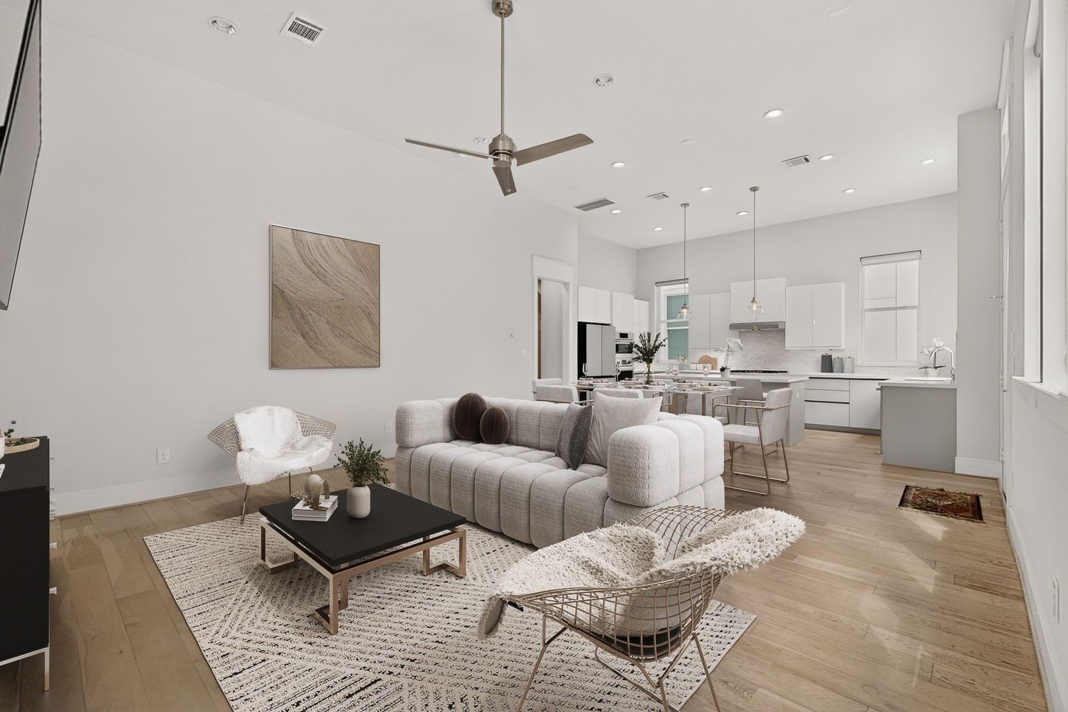 Experience modern elegance in this open-concept living space, featuring sleek light wood floors, a minimalist kitchen with high-end finishes, and ample natural light throughout.