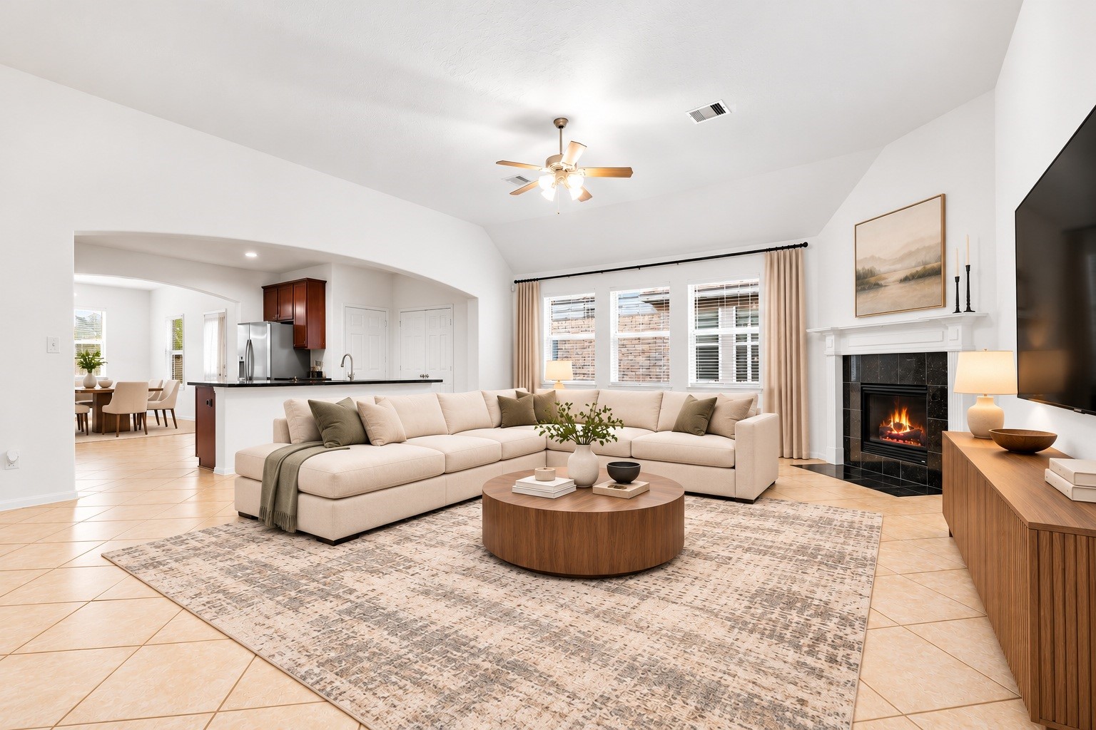 Natural light pours through three windows dressed in new blinds, while a wide arched opening links the family room to the kitchen for a cozy, connected floor plan. Virtually staged. Natural light pours through three windows dressed in new blinds, while a wide arched opening links the family room to the kitchen for a cozy, connected floor plan. Virtually staged.
