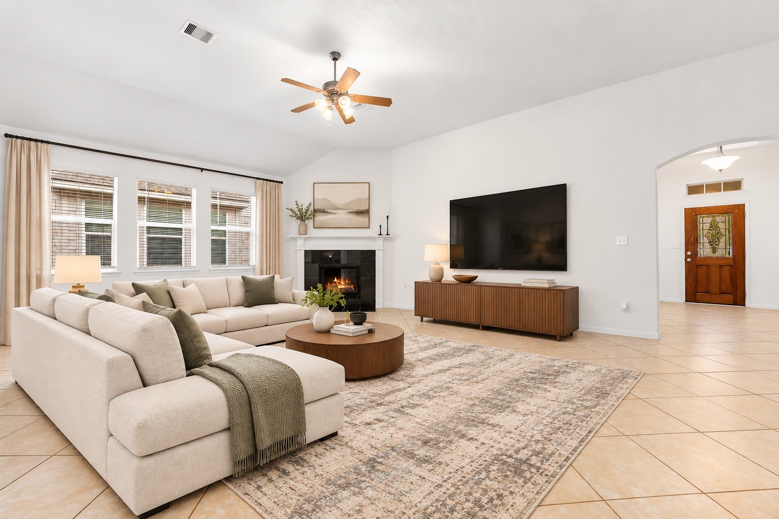 Gather around the refurbished gas log fireplace, the heart of the family room. A crisp white mantel and dark tile surround sit beneath a soaring vaulted ceiling with a ceiling fan. Virtually staged. Gather around the refurbished gas log fireplace, the heart of the family room. A crisp white mantel and dark tile surround sit beneath a soaring vaulted ceiling with a ceiling fan. Virtually staged.