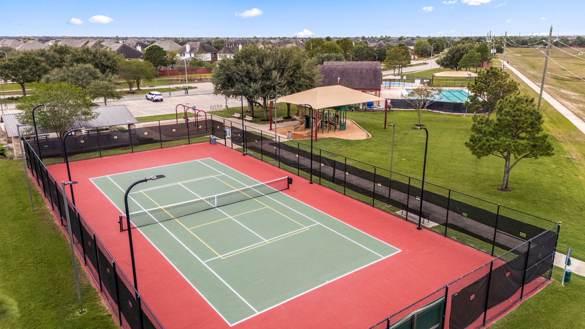 Silver Ranchs fenced, lighted recreation court is marked for both tennis and pickleball. The court is conveniently positioned beside the community playground and pool complex.