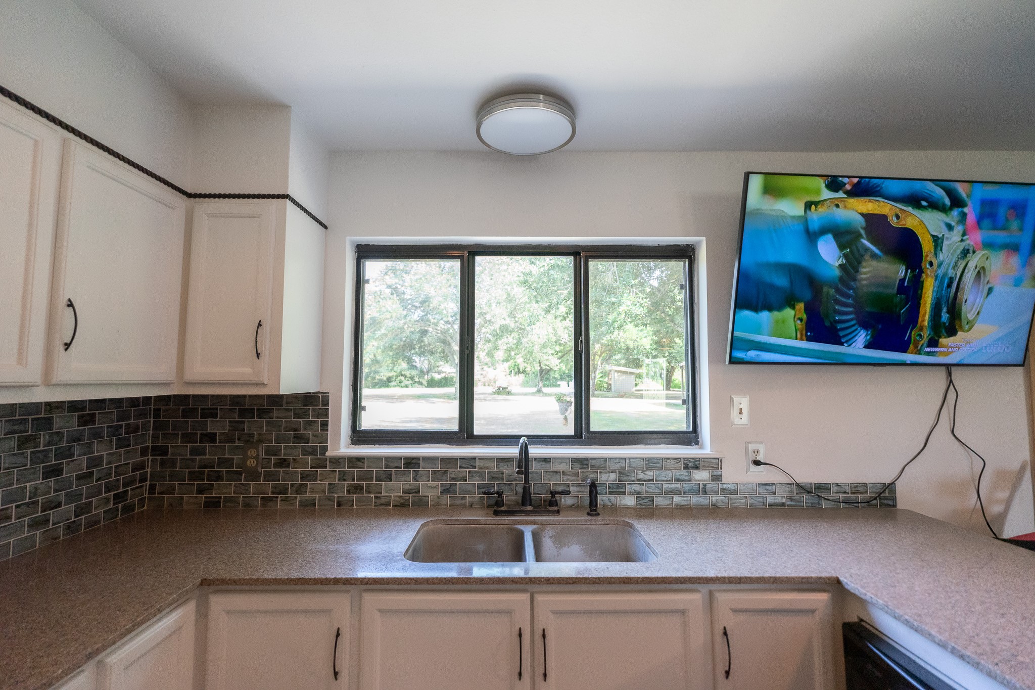 A sink with a view into the backyard.