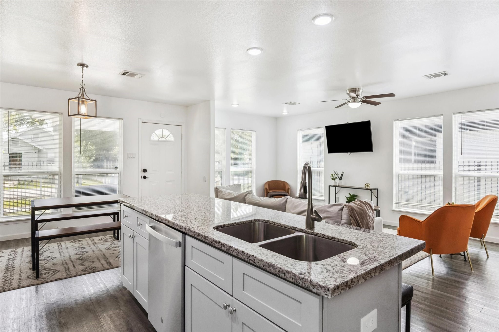An open-concept layout filled with natural light connects the kitchen, dining, and living areas seamlessly. Large windows and modern finishes create a bright, inviting space ideal for both relaxing and entertaining.