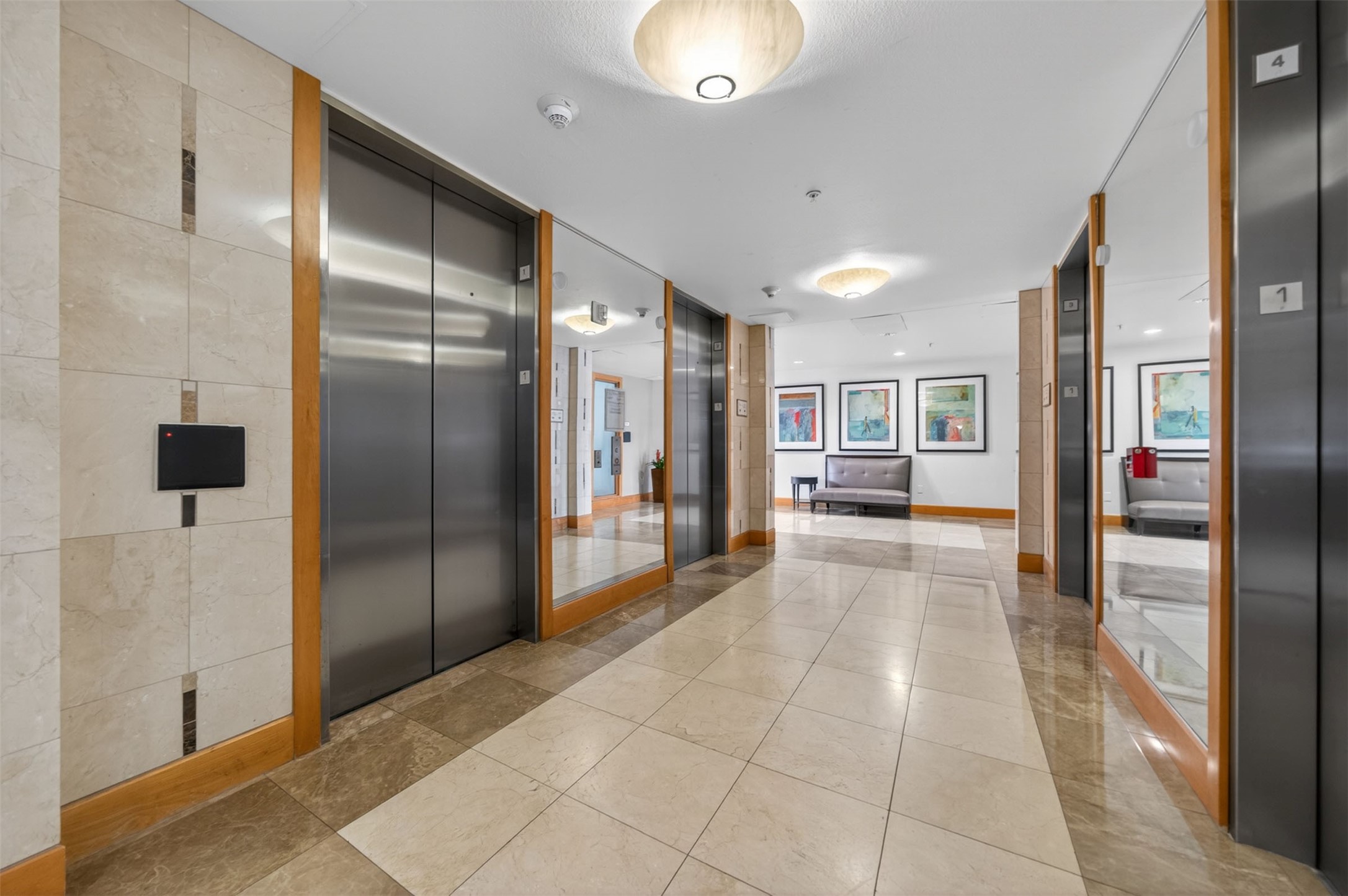 Elegant lobby featuring sleek elevators, polished tile flooring, modern lighting, and stylish seating, creating a welcoming and sophisticated entrance.