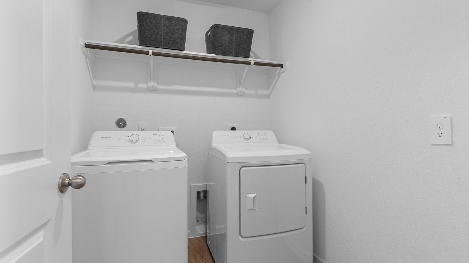 Spacious laundry room with washer and dryer connections, hanging rod, and vinyl wood flooring