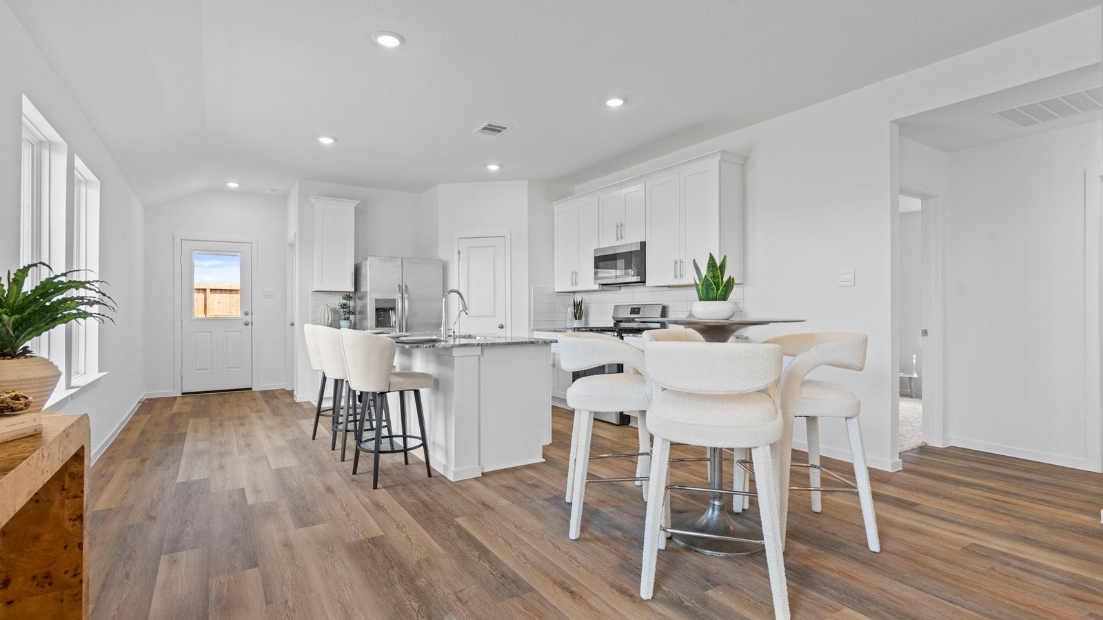 Formal dining area with large windows, vinyl wood floors, and view of the backyard.