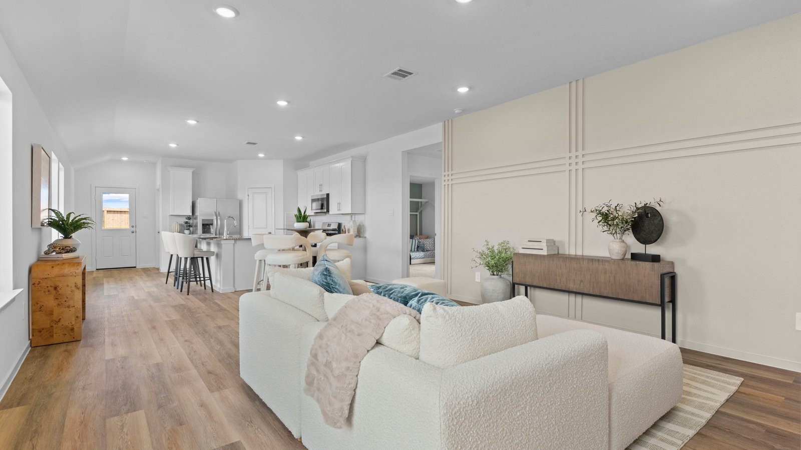 A well-organized living room that includes a kitchen and dining area, creating a warm and welcoming environment for gatherings.