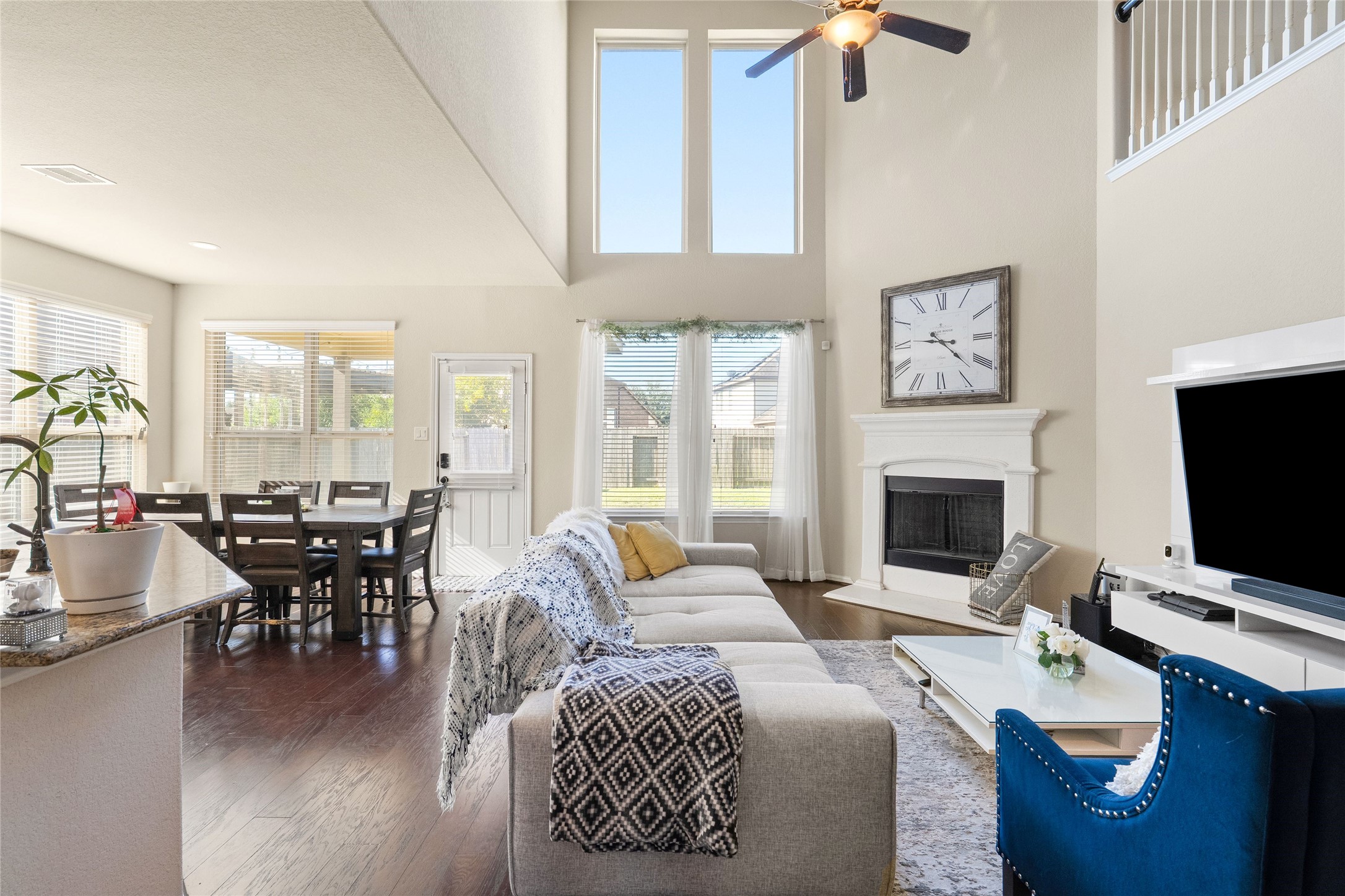 Bright and inviting living area with vaulted ceilings, large windows, and a cozy fireplace. The open layout seamlessly connects to a dining area, making it perfect for entertaining. Bright and inviting living area with vaulted ceilings, large windows, and a cozy fireplace. The open layout seamlessly connects to a dining area, making it perfect for entertaining.