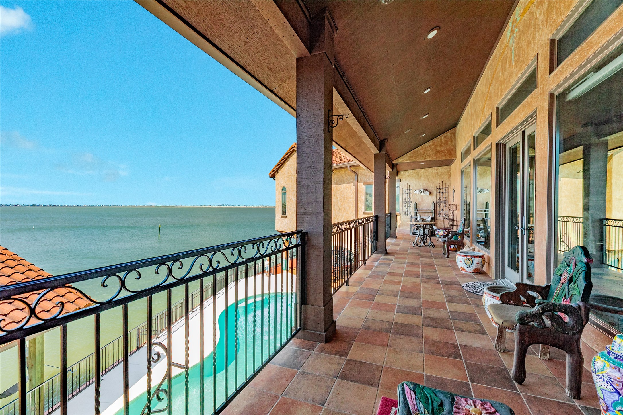 Balcony off of living area, overlooking pool and bay