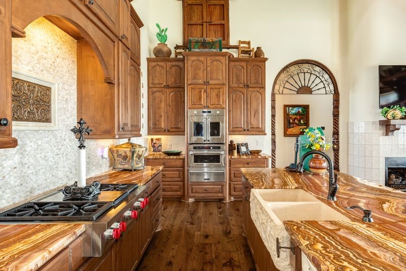 Large kitchen with onyx countertops, gas cooktop, double ovens, walkin pantry