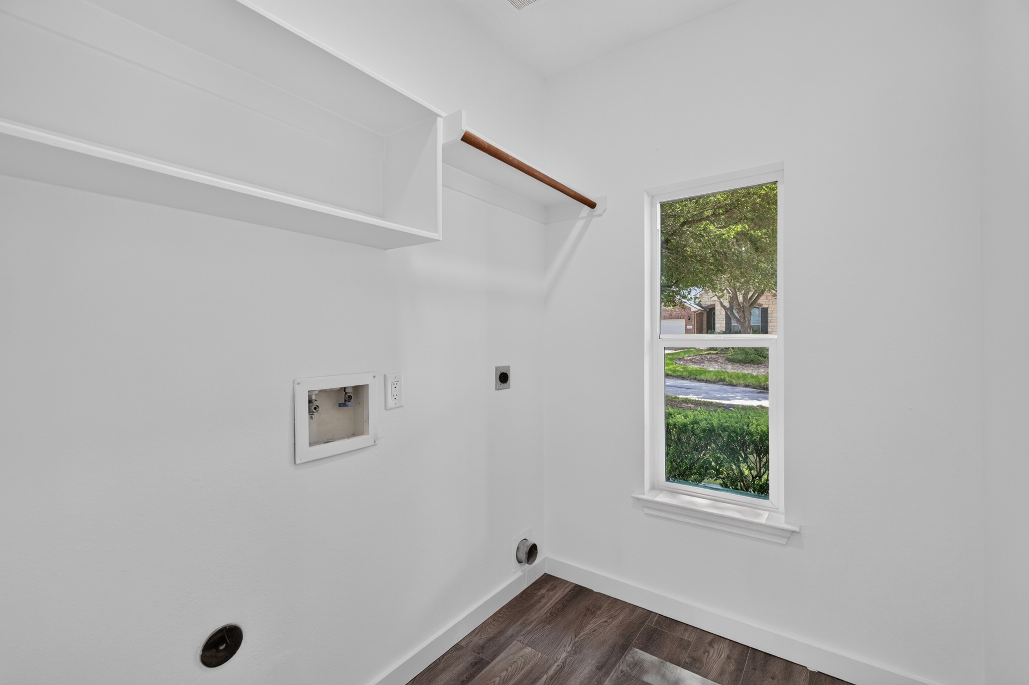 Natural light fills this comfortable secondary bedroom at 18 Griffin Hill Court through a bright window that adds warmth and a connection to the outdoors. Generous proportions, pristine white walls, and dark hardwood-style flooring make this a welcoming space ready for any configuration  from a restful guest room to a creative home studio.