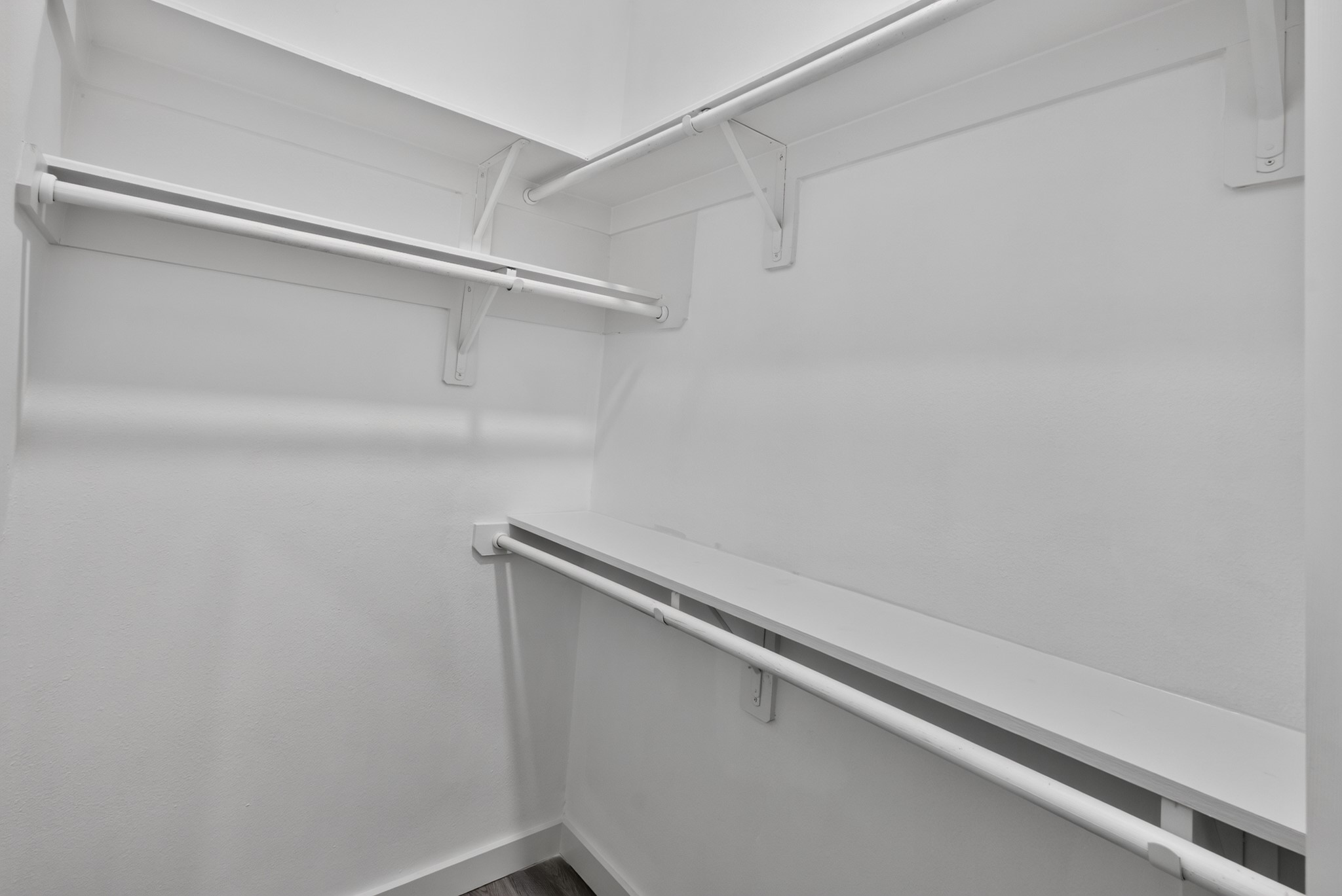 Another view of the impressive walk-in closet at 18 Griffin Hill Court showcases the full extent of its built-in organization system, including multiple hanging rods and open shelving sections. Whether for shoes, seasonal wardrobe, or everyday essentials, this closet provides a beautifully functional and generously sized personal storage solution.