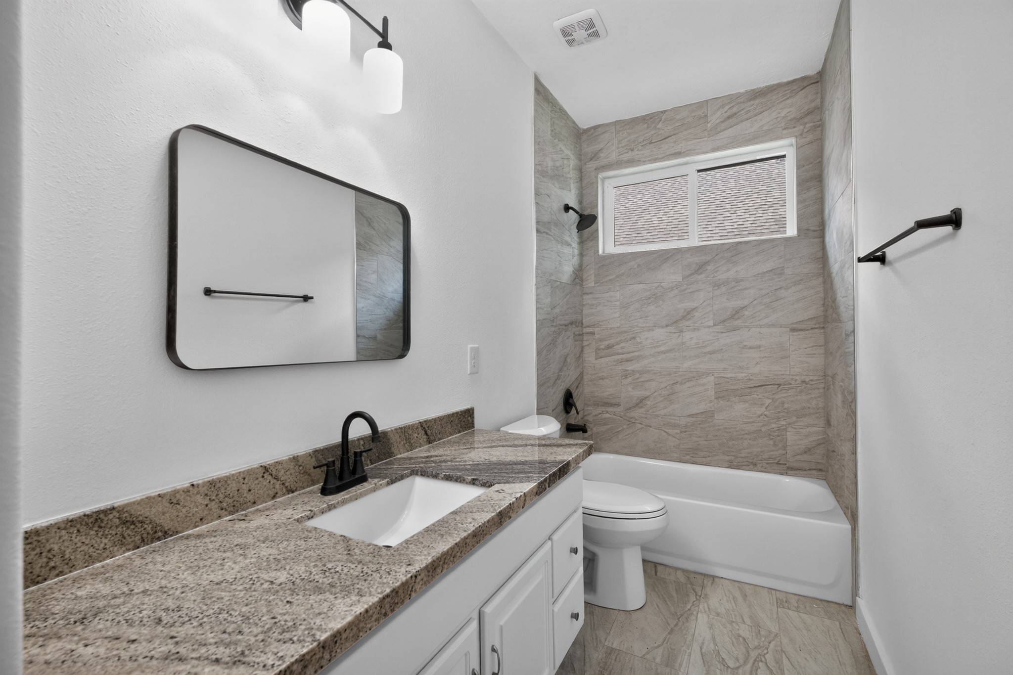 A beautifully appointed secondary bathroom at 18 Griffin Hill Court features rich tile walls, a modern vanity with sink, an oversized mirror, and quality fixtures throughout. Clean, contemporary, and thoughtfully designed, this bathroom provides both the everyday functionality and the polished aesthetic appeal that today's discerning homebuyer expects.
