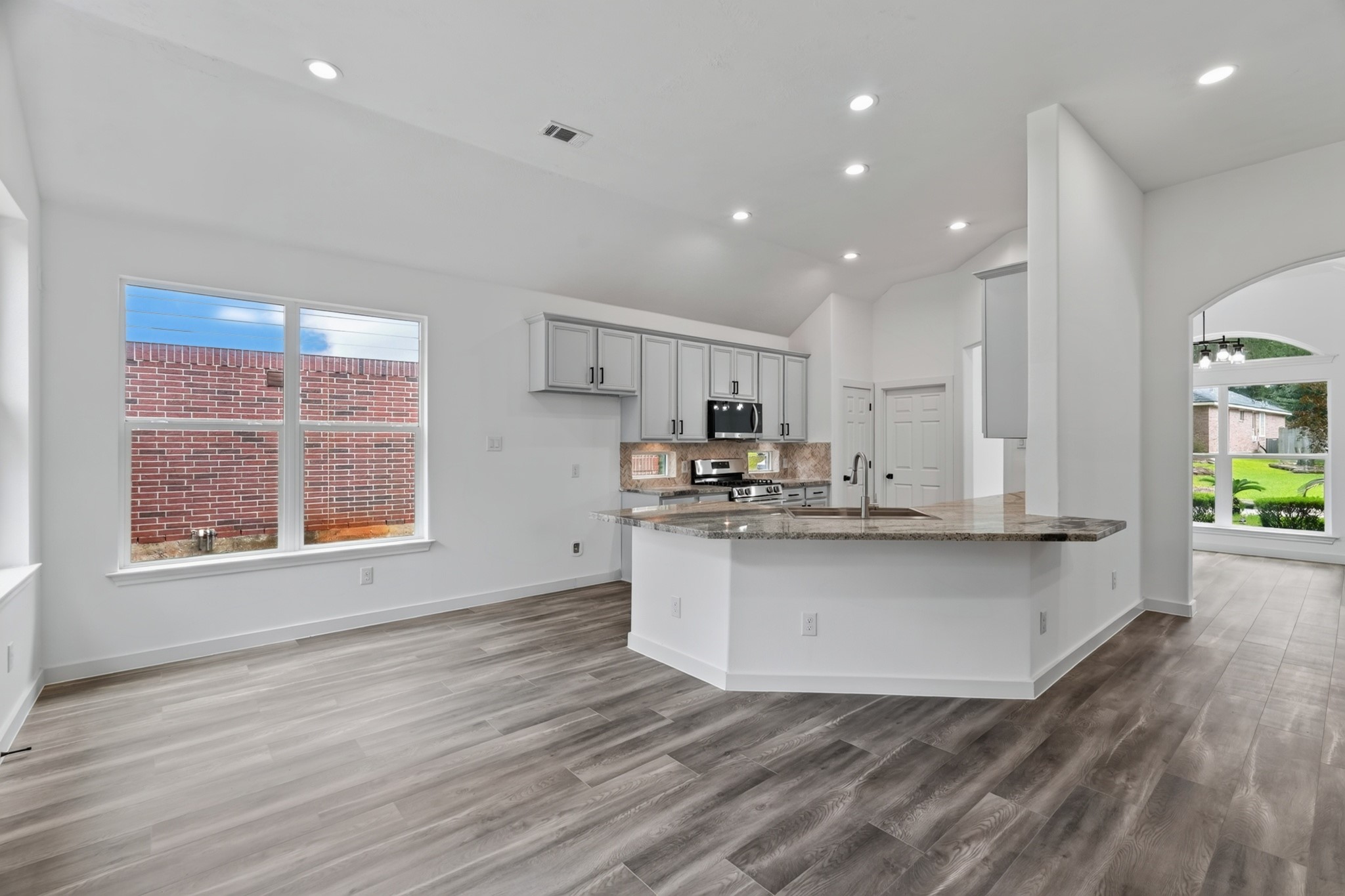 The stunning kitchen at 18 Griffin Hill Court is a true centerpiece, featuring gorgeous light stone countertops, elegant grey cabinetry, and ample workspace for cooking and entertaining. Abundant natural light fills this beautifully appointed space throughout the day, making this kitchen as functional as it is visually stunning.