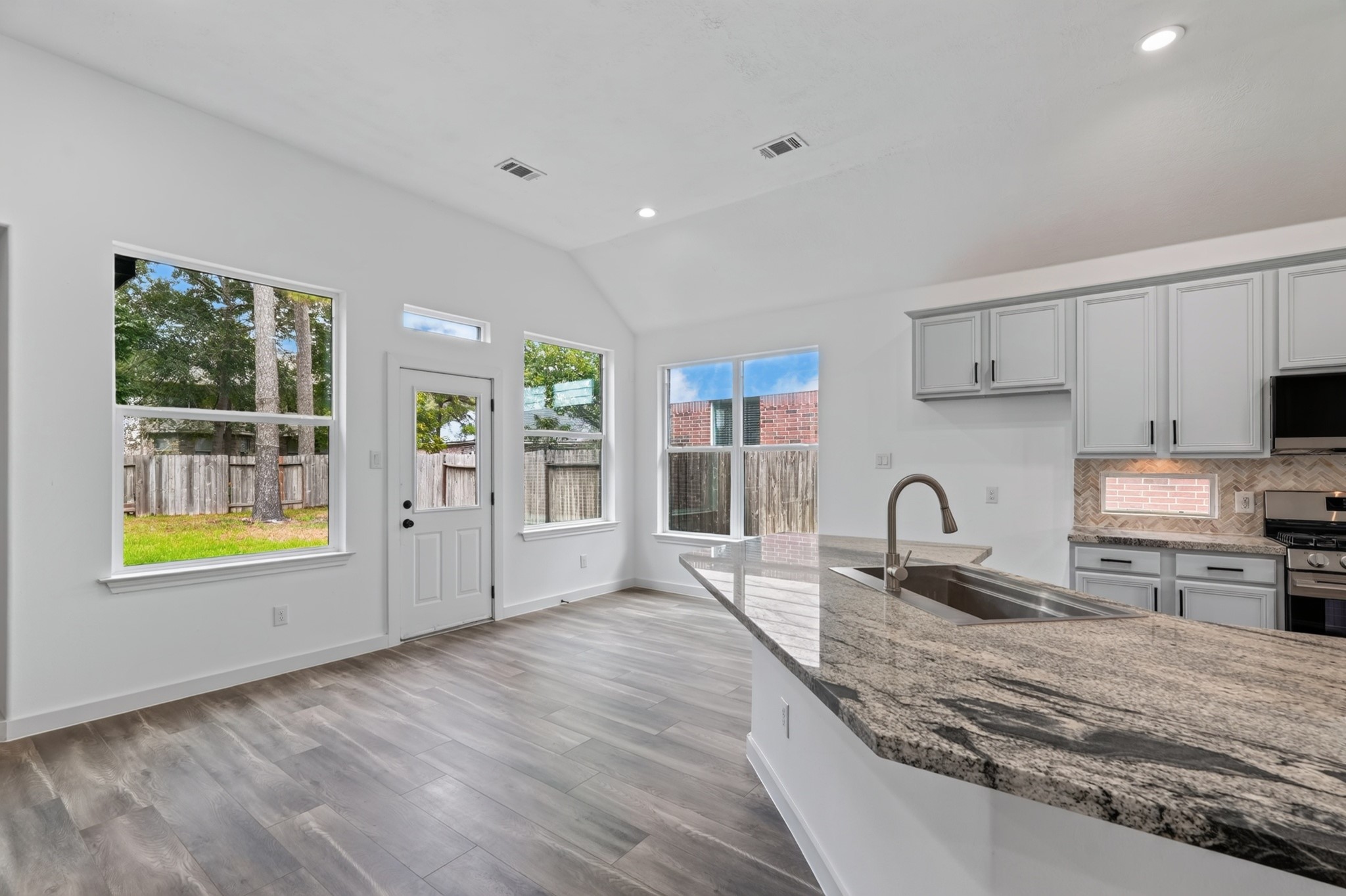 A wide-angle view of the breakfast nook at 18 Griffin Hill Court captures the home's impressive open-concept layout.
