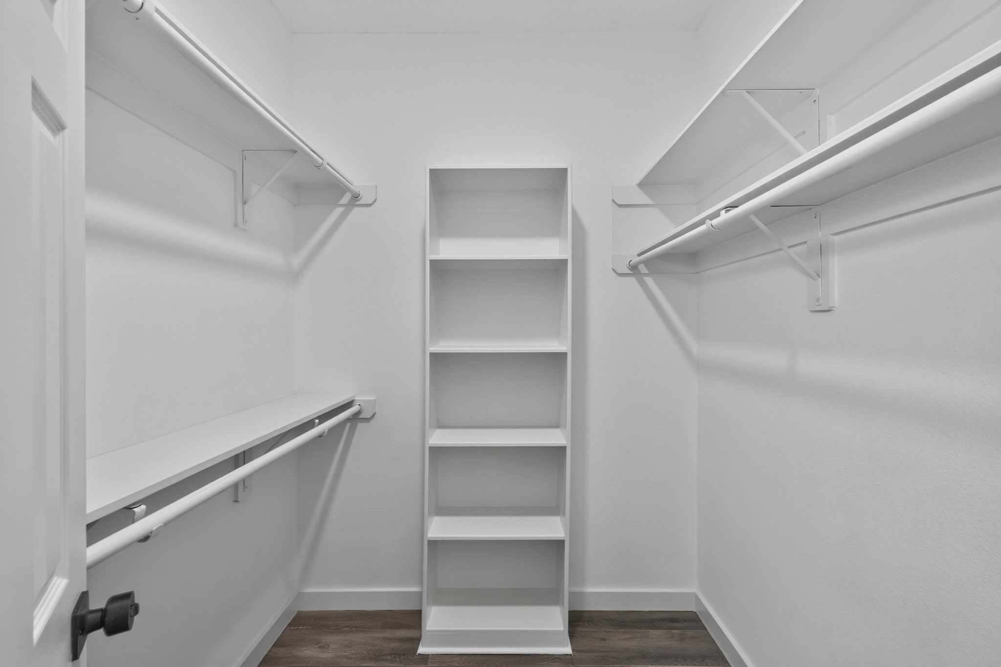 The spacious walk-in closet at 18 Griffin Hill Court features generous built-in shelving, double hanging rods, and ample storage capacity for a full wardrobe and everything beyond. This perfectly organized closet is a key feature of the primary suite, providing the kind of storage that makes everyday living feel effortless and truly luxurious.