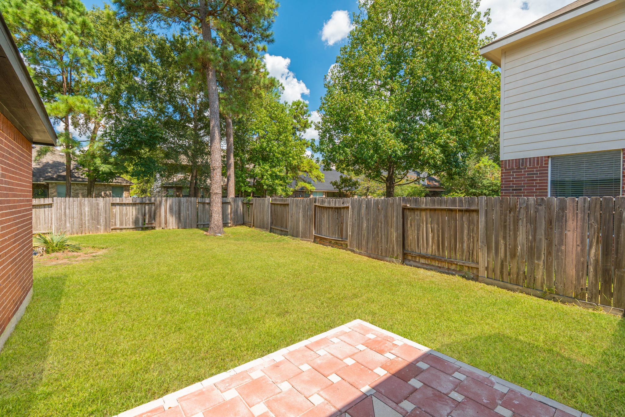 The side and rear yard of 18 Griffin Hill Court offer beautiful green space framed by mature trees and a sturdy privacy fence. This well-maintained outdoor area provides the ideal setting for outdoor living  whether you envision morning coffee on the patio, weekend gardening, or building the backyard oasis that the space and Texas sunshine make possible.