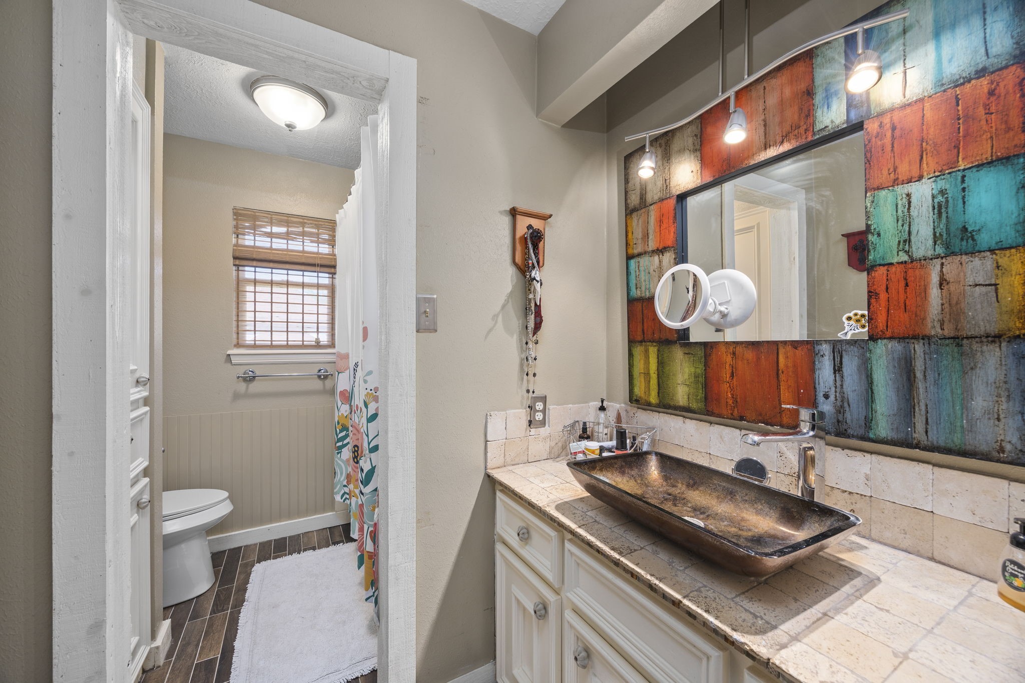 Shared upstairs bathroom features a distinctive vessel sink, decorative tile accents, and a tub/shower combination with a separate vanity area.
