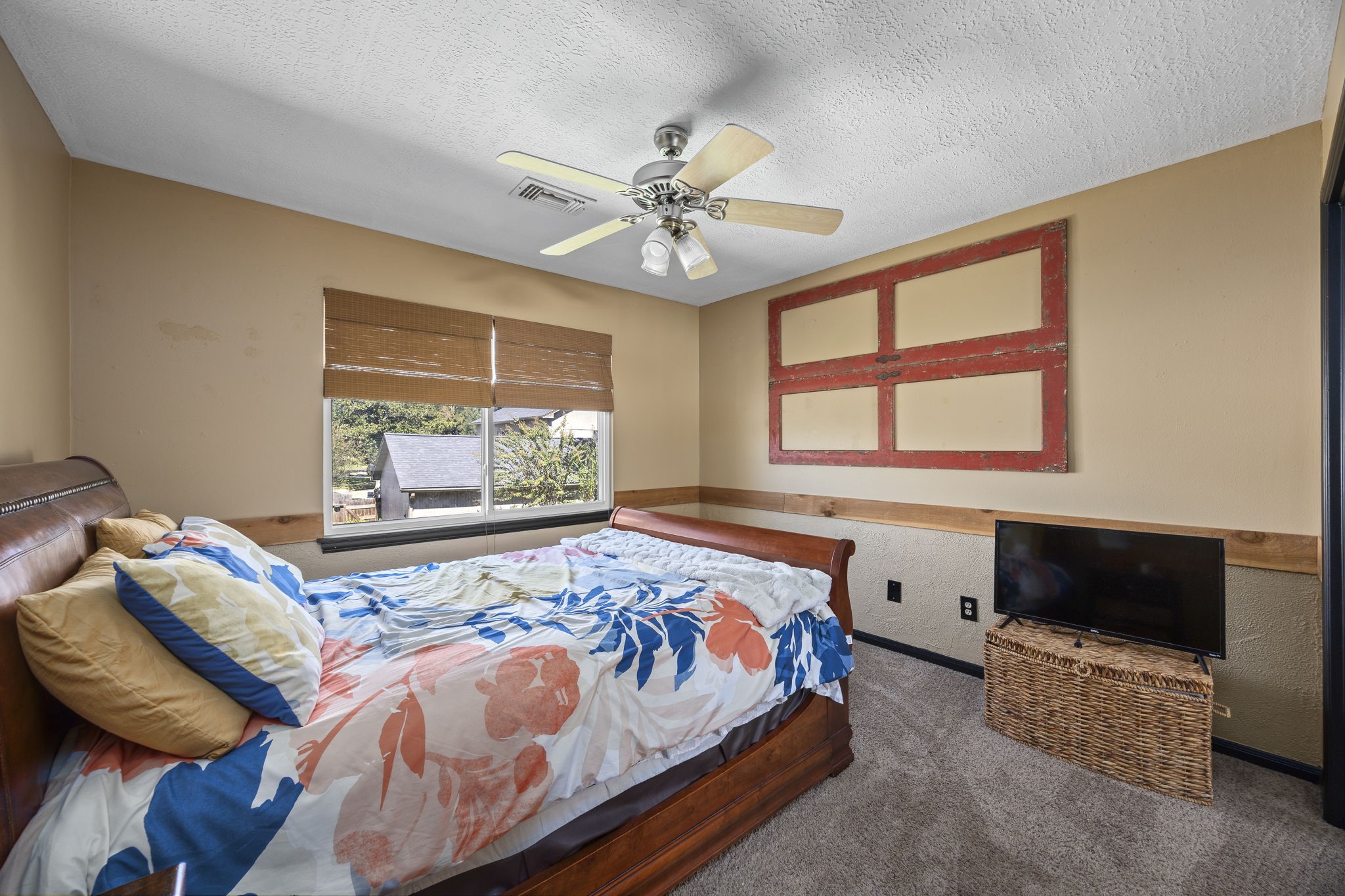 Upstairs bedroom features a ceiling fan, spacious closet, and window overlooking the outdoors. Convenient access to a shared bathroom.
