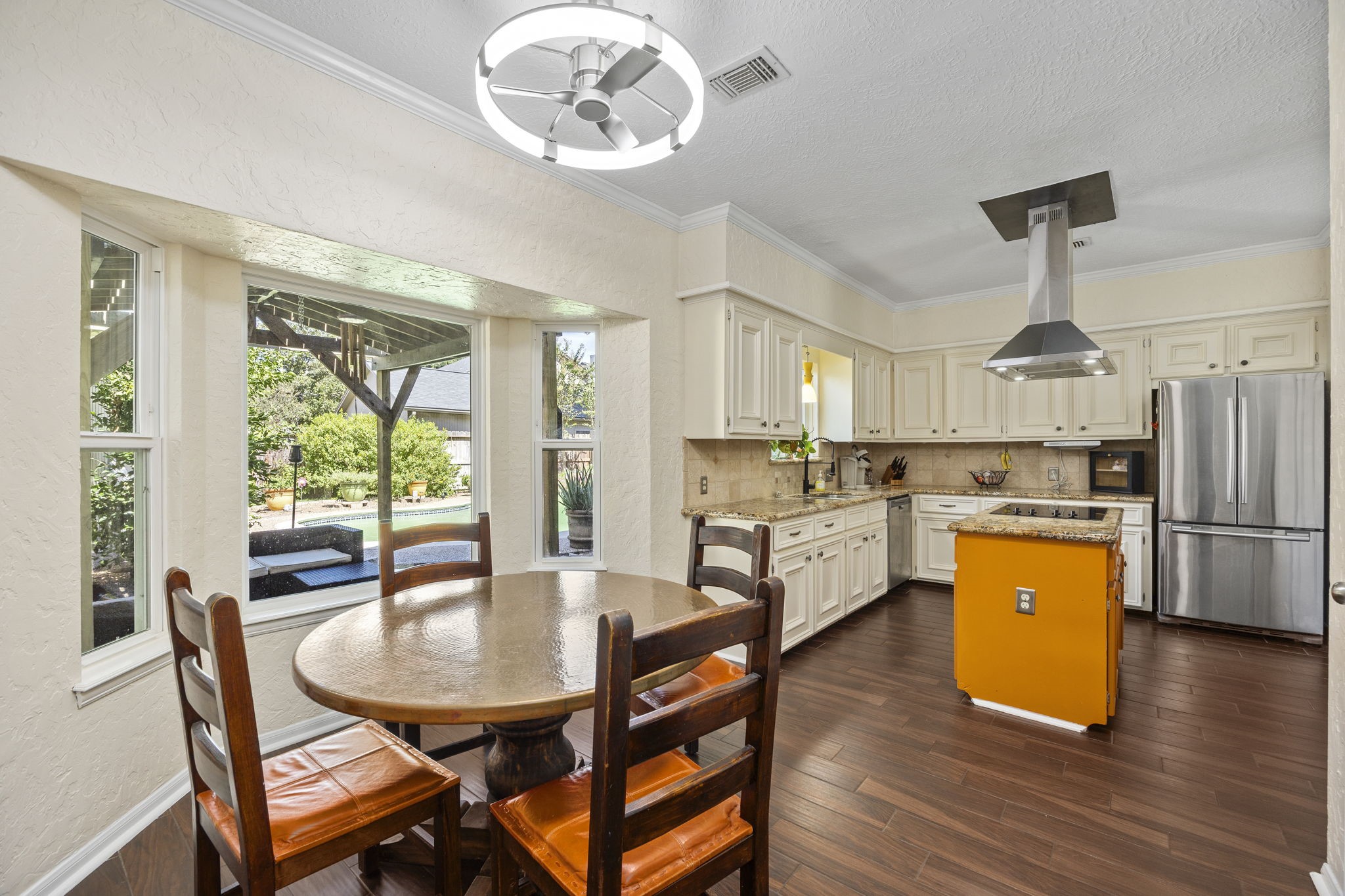 The breakfast area features a charming bay window overlooking the backyard and pool, with space for casual dining and an open connection to the kitchen. A comfortable spot for morning coffee or everyday meals.