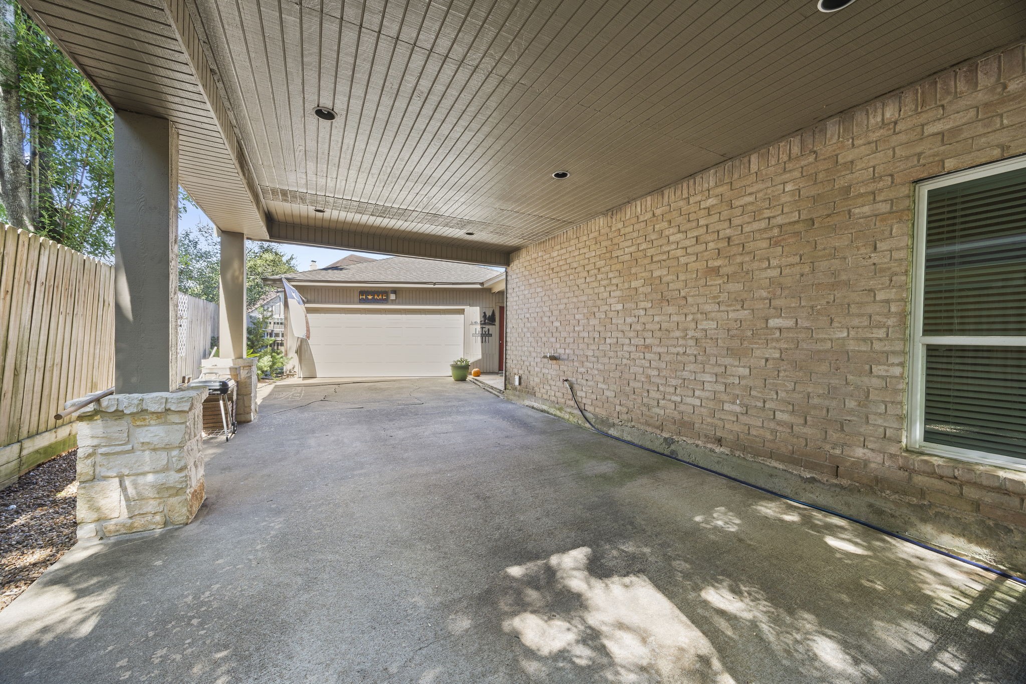 Porte-cochere provides covered access to the home with protection from sun and rain. The extended driveway offers additional parking and plenty of space for outdoor activities and play, leading to the detached garage.