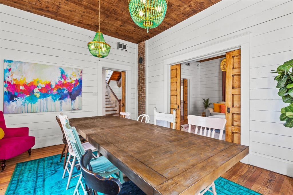 Dining room with stained wood ceiling accent, pocket doors, brick wall exposure