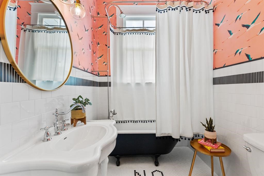 Full bath on the first floor- updated tile flooring, claw foot tub/shower combo, beautiful wallpaper