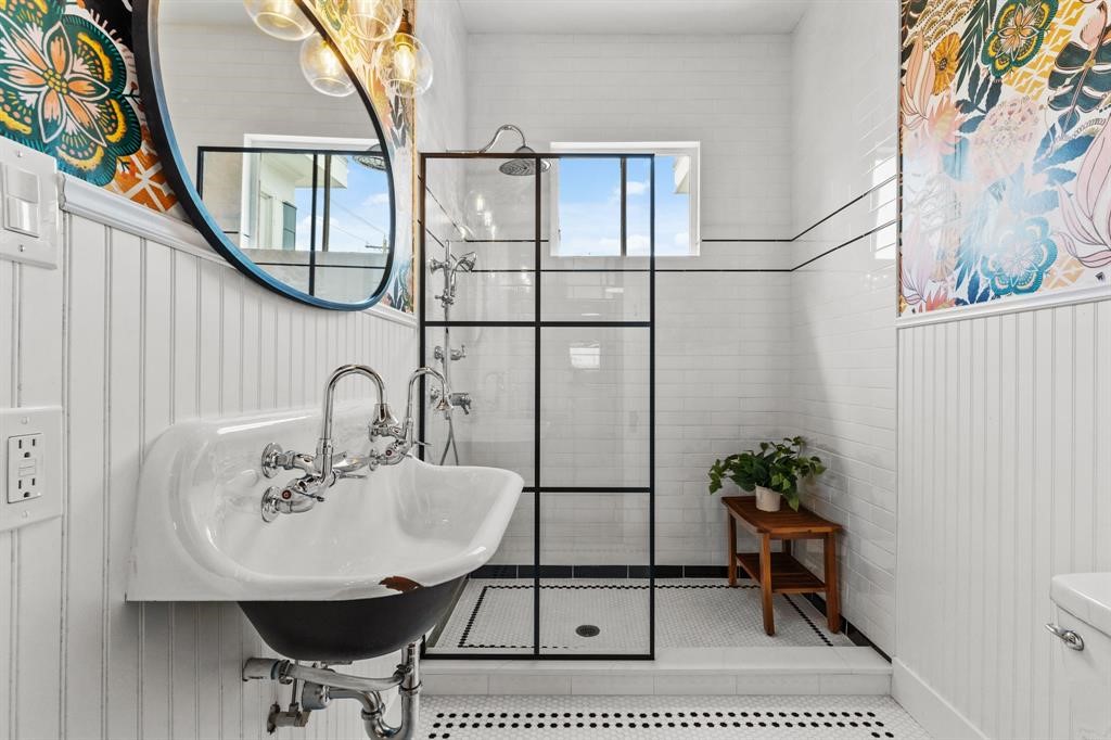 Full bath on the second floor. Beautiful wallpaper, framed mirror and stand alone, fully tiled shower.