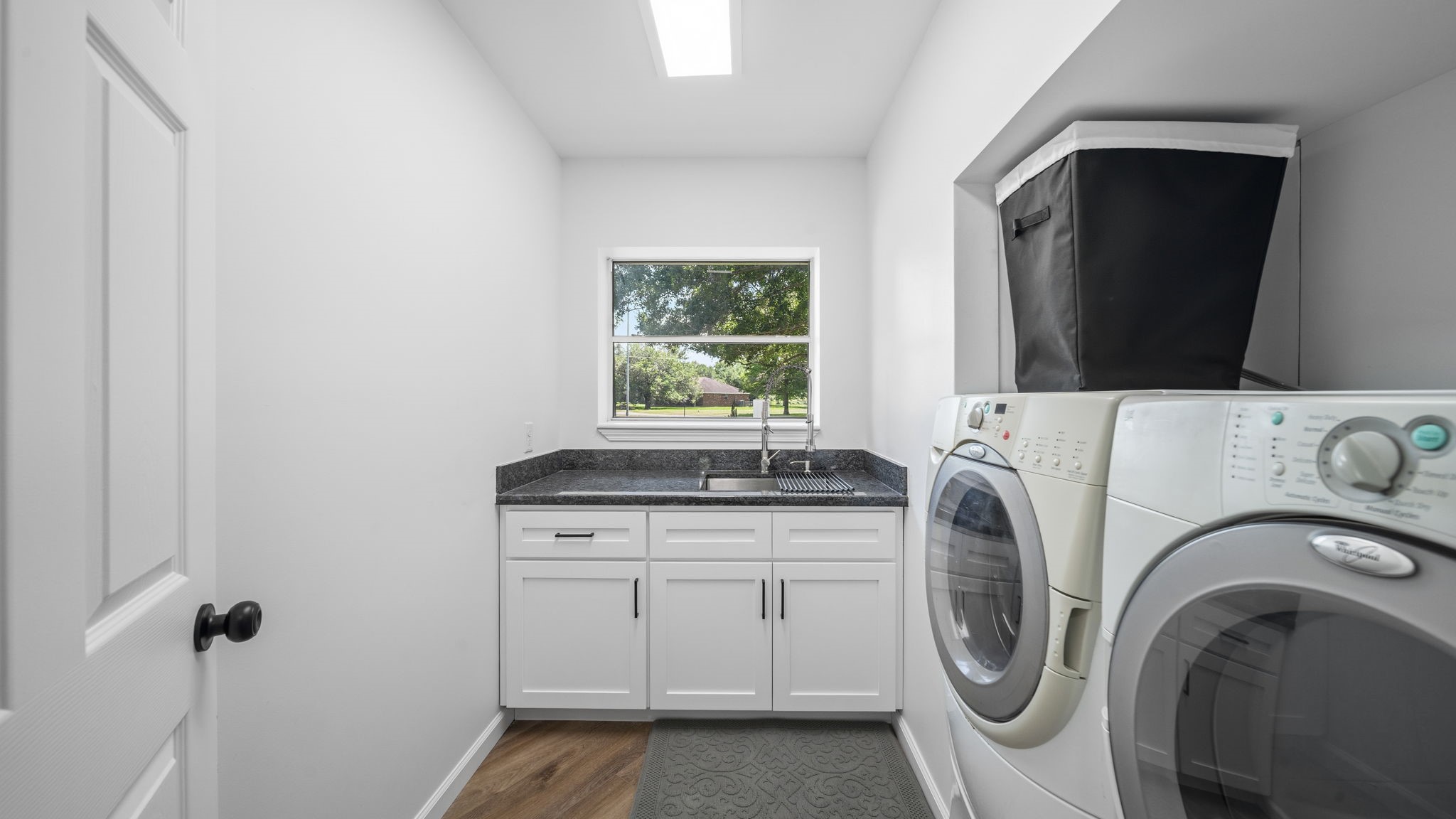 Laundry room with deep sink and cabinets washer and dryer stay