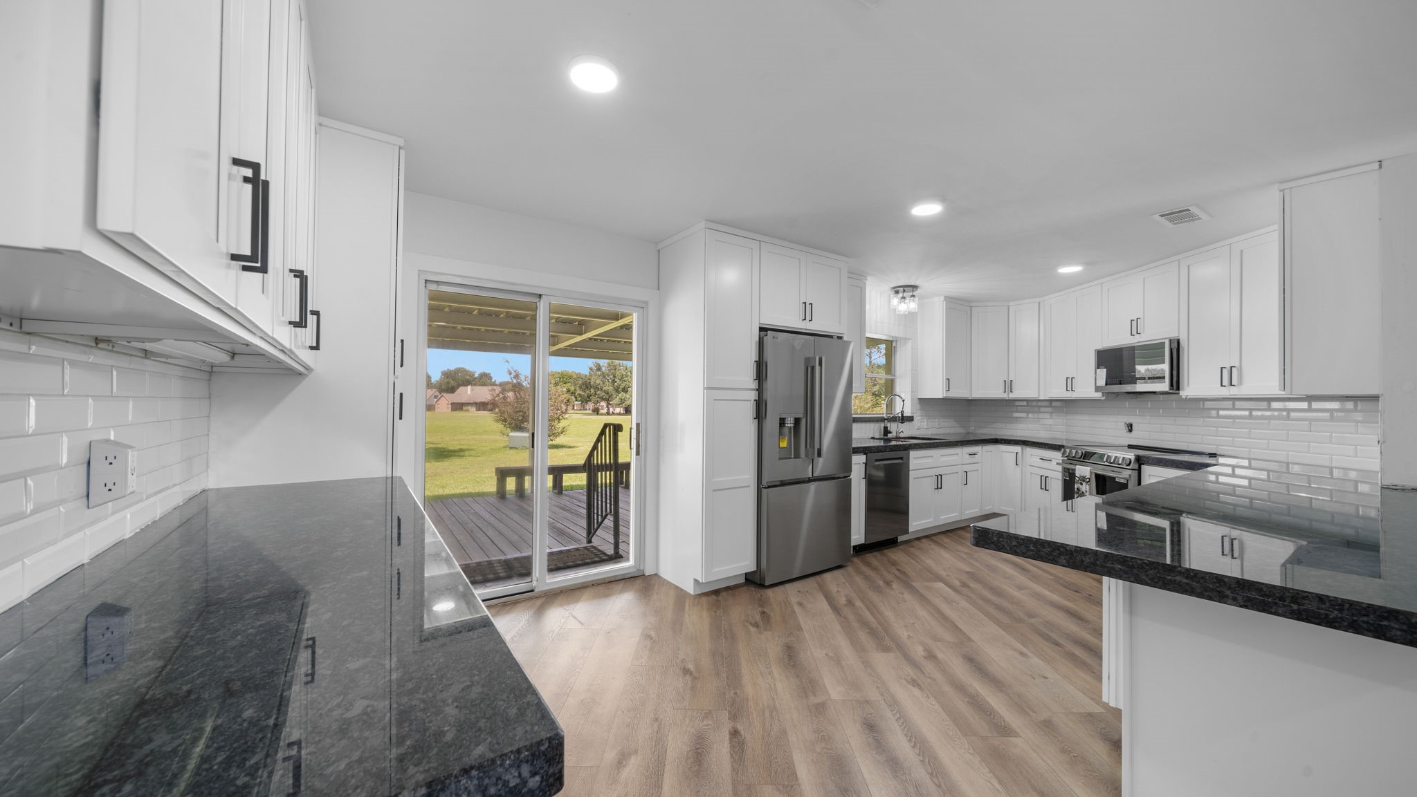 Another view of all the cabinetry.kitchen sink has prep station, reverse osmosis filtered water faucet and filters to refrigerator, new microwave, 5 burner induction range with large convection oven, 2nd separate full size convection oven, new Dishwasher